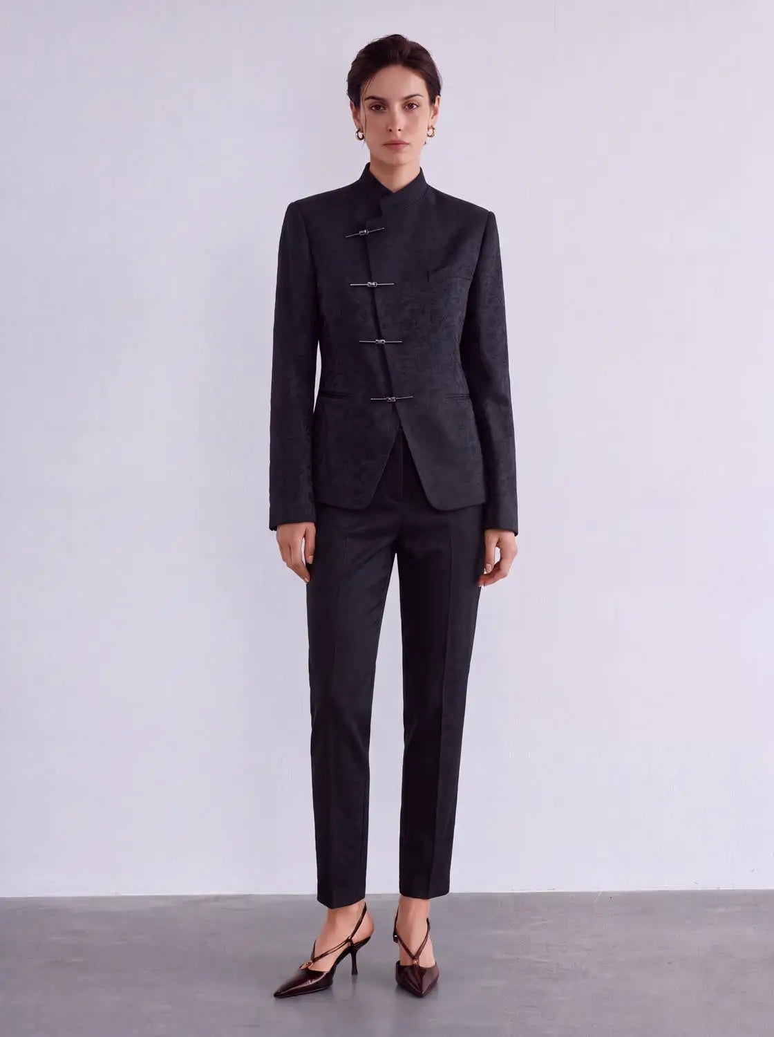 Mandarin-collar textured cotton-blend tailored blazer and matching pants set in black with front metal clasps