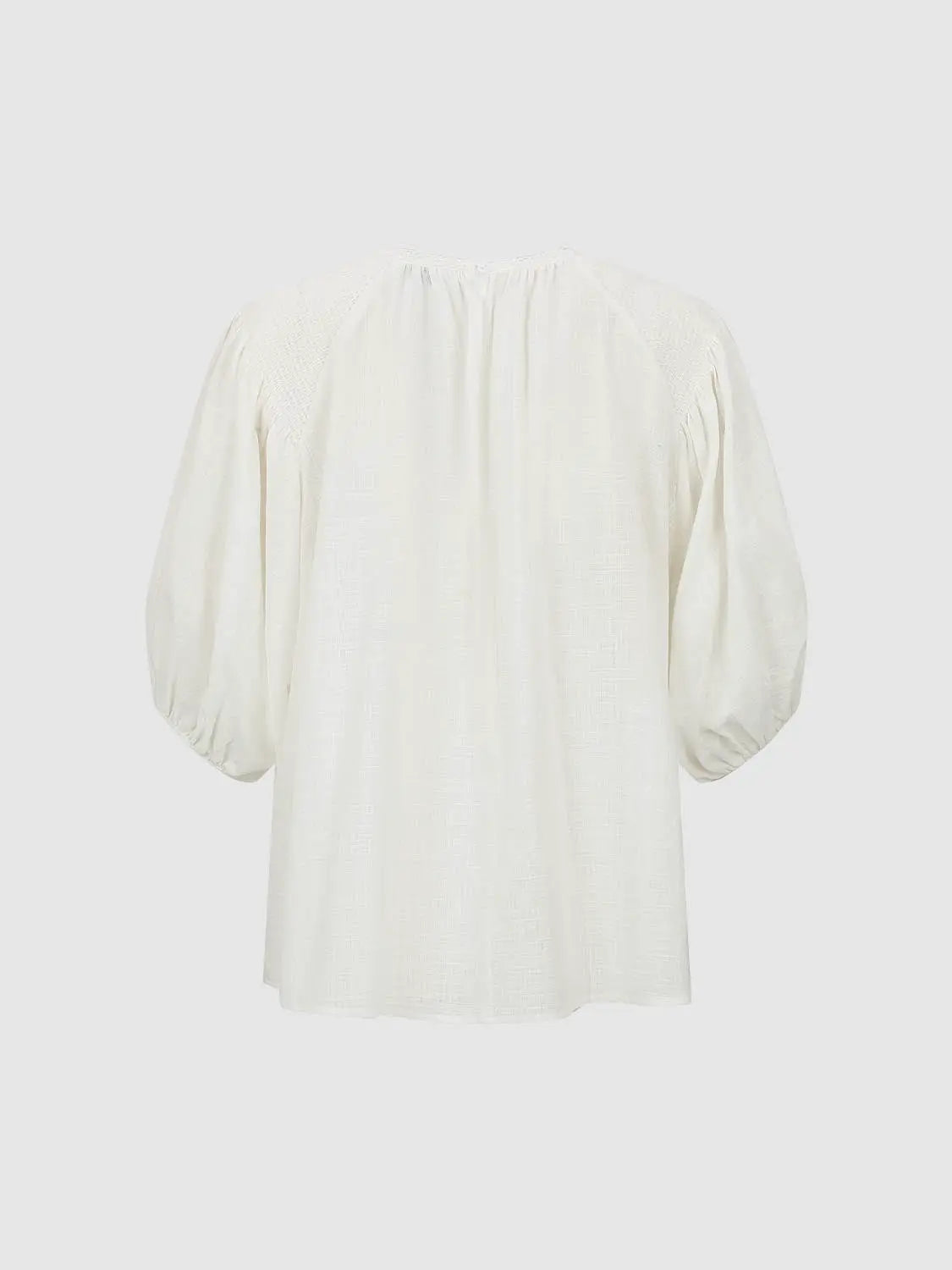 Blouse, white textured fabric with oversized puff sleeves, back view.