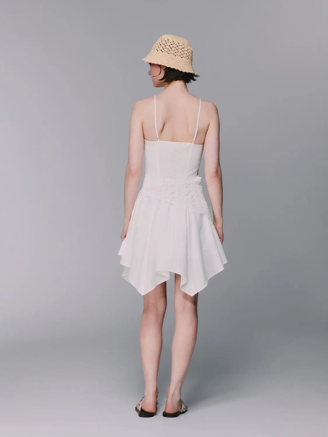 A-line spaghetti-strap linen-blend dress in white with crocheted waistband, back view.