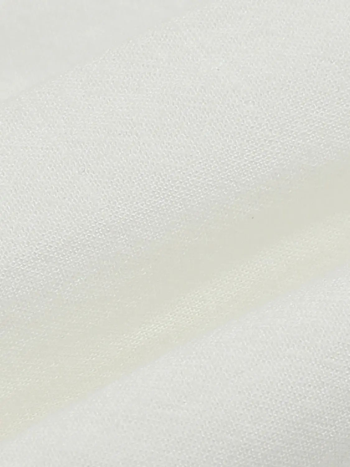 Cotton lace dress fabric close-up in white with lightweight lining hints