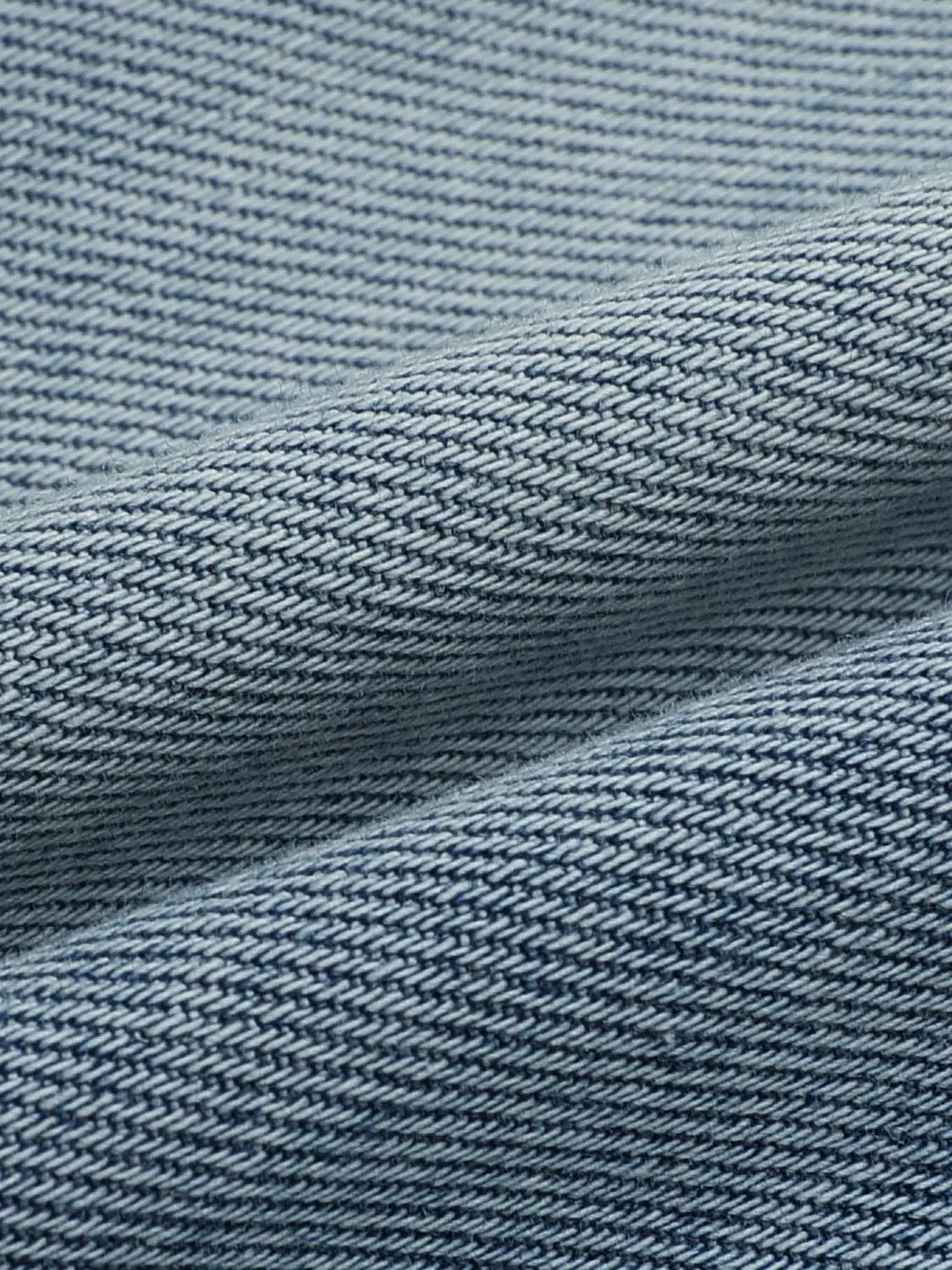 Wide-leg cotton jeans close-up of blue denim fabric with a tight diagonal weave, highlighting the classic jean texture