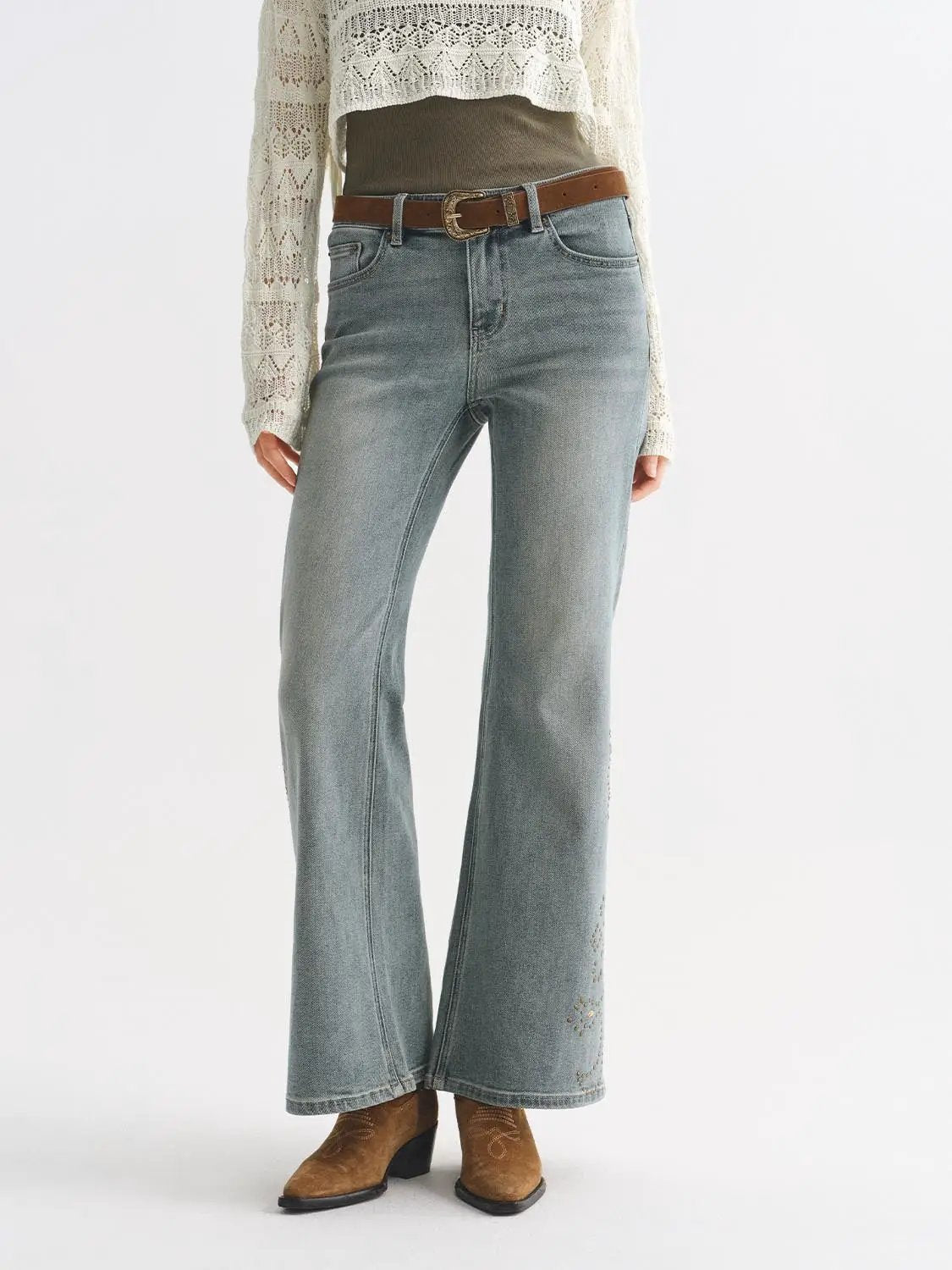 Jeans, light-wash wide-leg denim with brown belt on a model wearing a cream crochet sweater.
