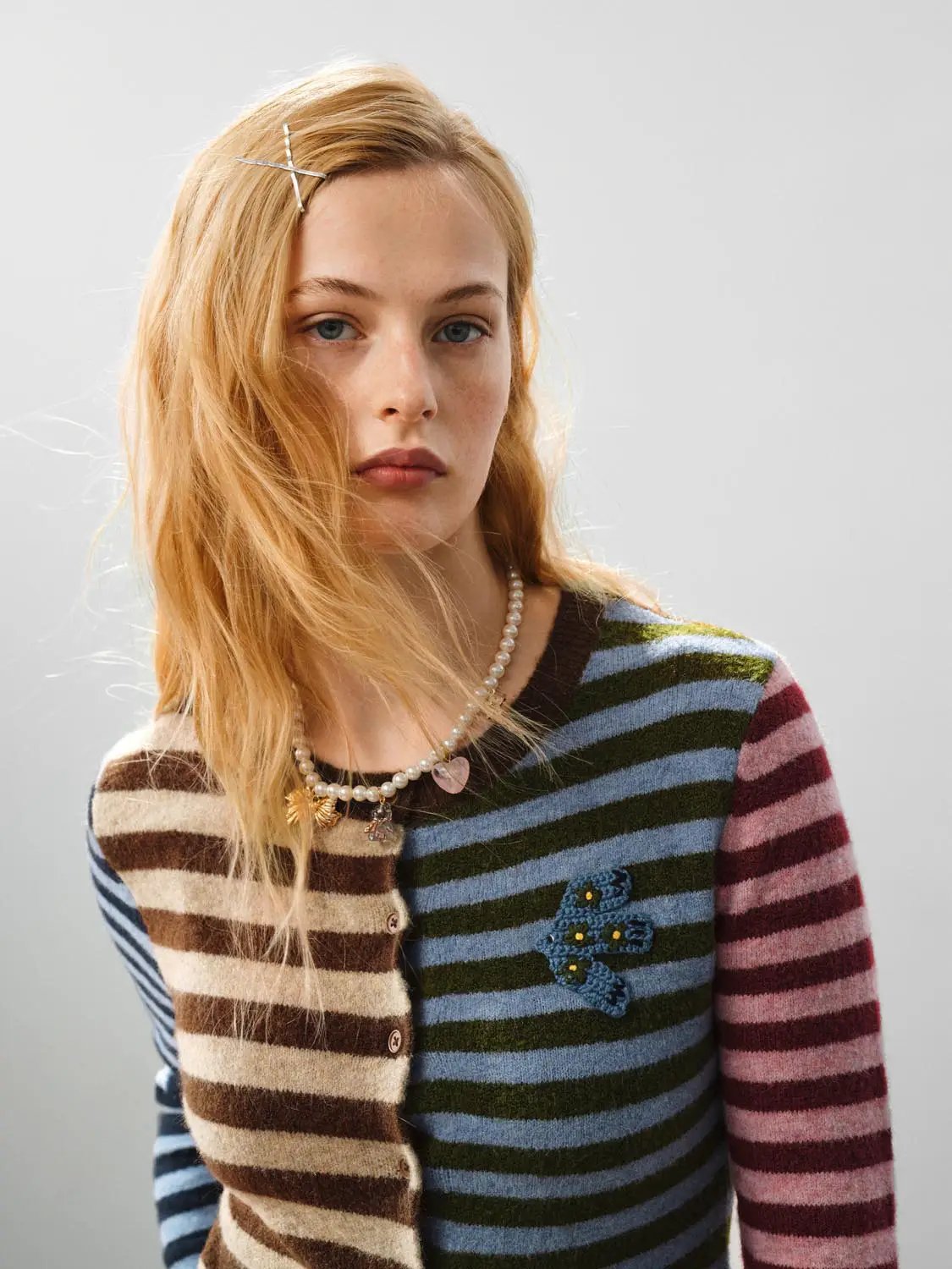 Embroidered striped knit cardigan, crew neck, long sleeves; multicolor stripes with blue floral embroidery patch