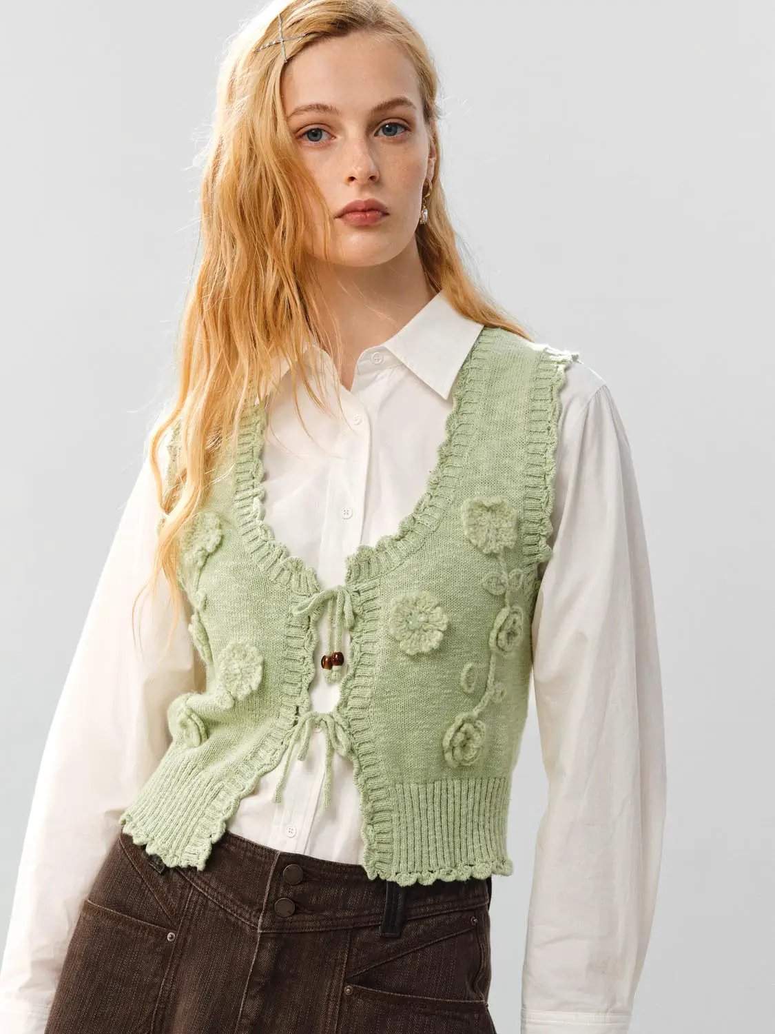 Floral ruffle tie V-neck sleeveless cotton vest in light green, worn over a white shirt