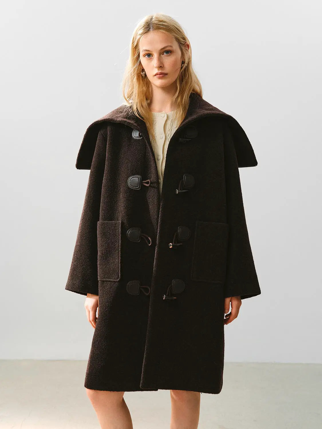 Coat, dark wool duffle with oversized collar, knee-length, toggle closures, front patch pockets.
