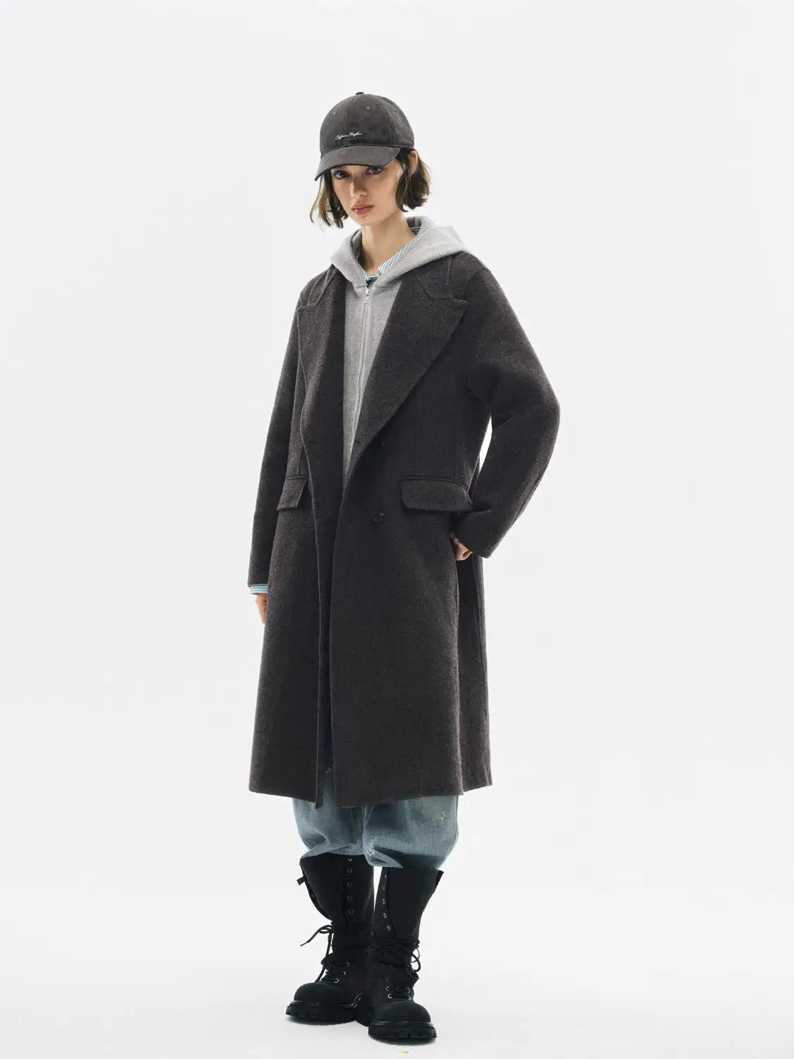 Coat by Urban Revivo Fashion; charcoal wool-blend long coat styled over a gray hoodie with jeans and black combat boots.