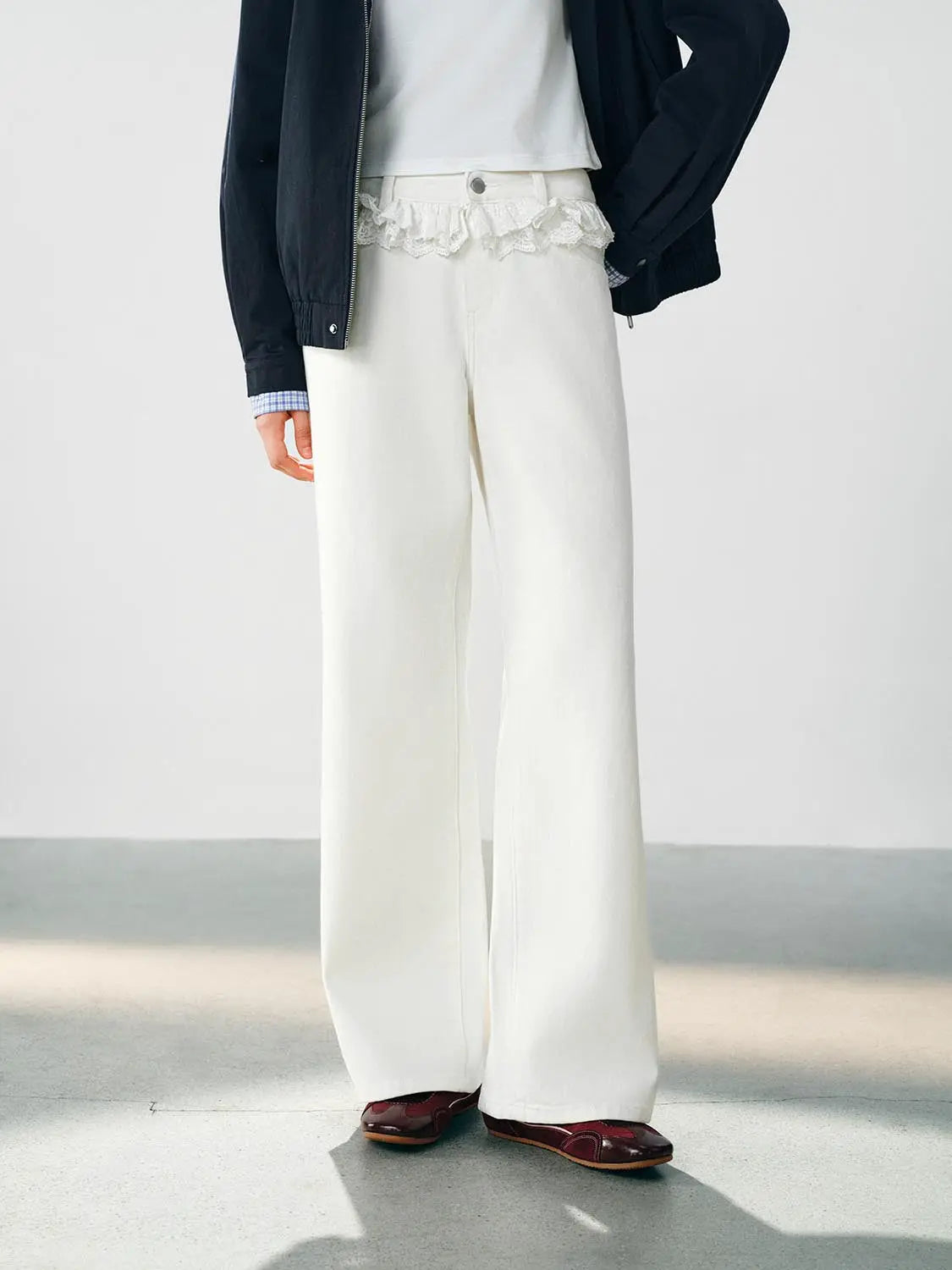 Jeans, white wide-leg with lace-trim waistband, paired with a navy jacket.