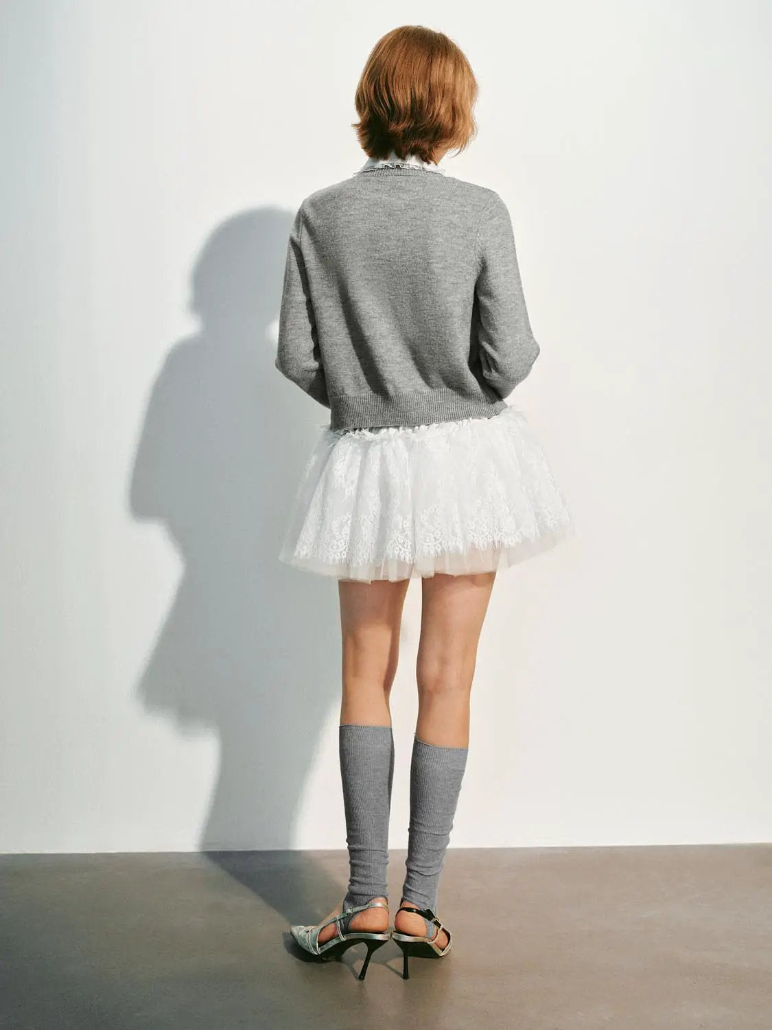 Knitwear cardigan in grey, back view, paired with white lace skirt; Urban Revivo Fashion.