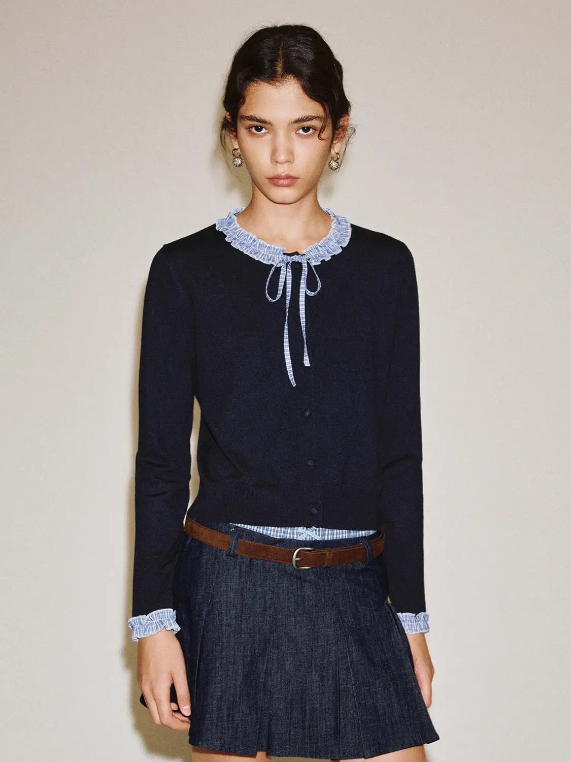Knitted cardigan in navy with light blue ruffled collar and cuffs, tie at the neckline.