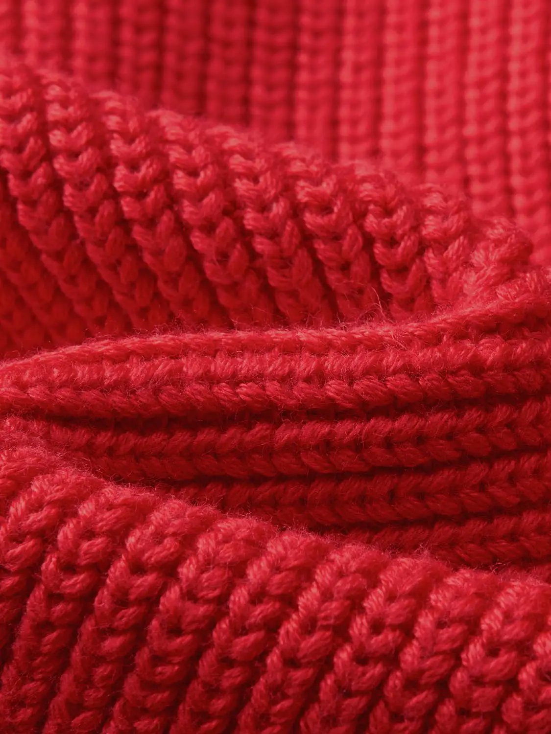 Knitwear jacket fabric; red knitted texture close-up