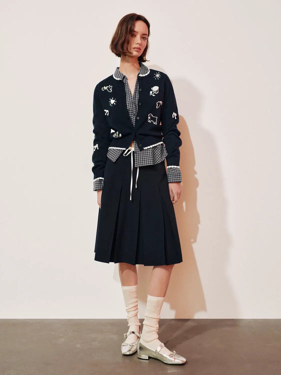 Graphic long sleeve ribbed knit cardigan in navy with white embroidered motifs.