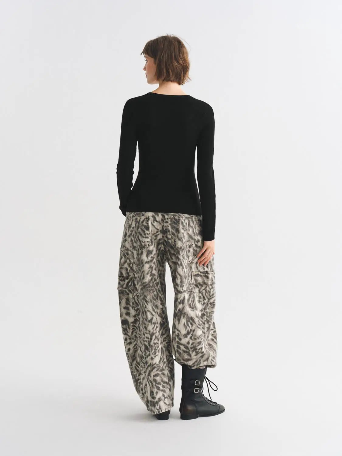 Knitted T-shirt, black, back view; three-piece outfit with gray camouflage cargo pants and black combat boots.