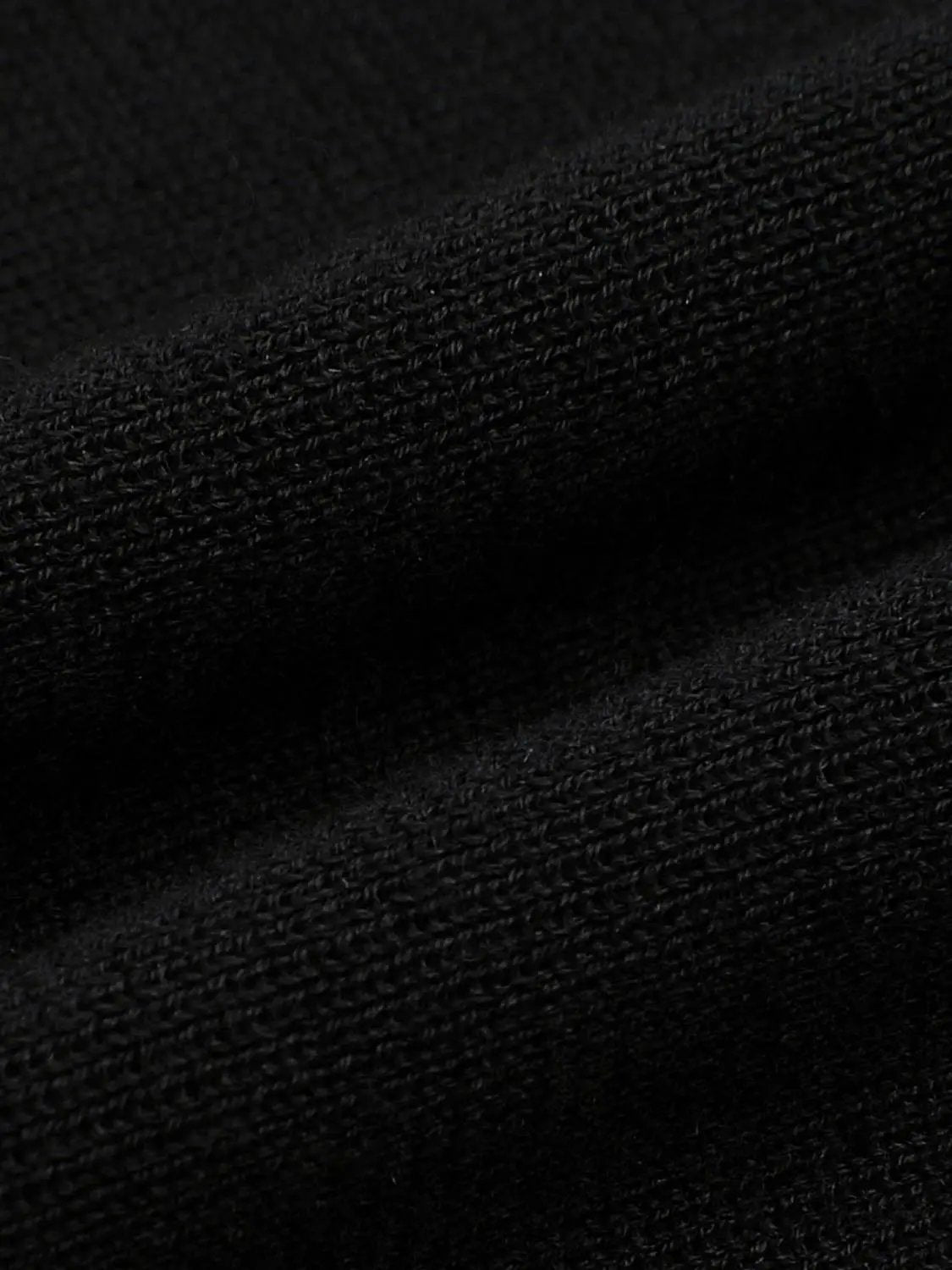 Knitted T-Shirts fabric close-up in black; textured knit surface