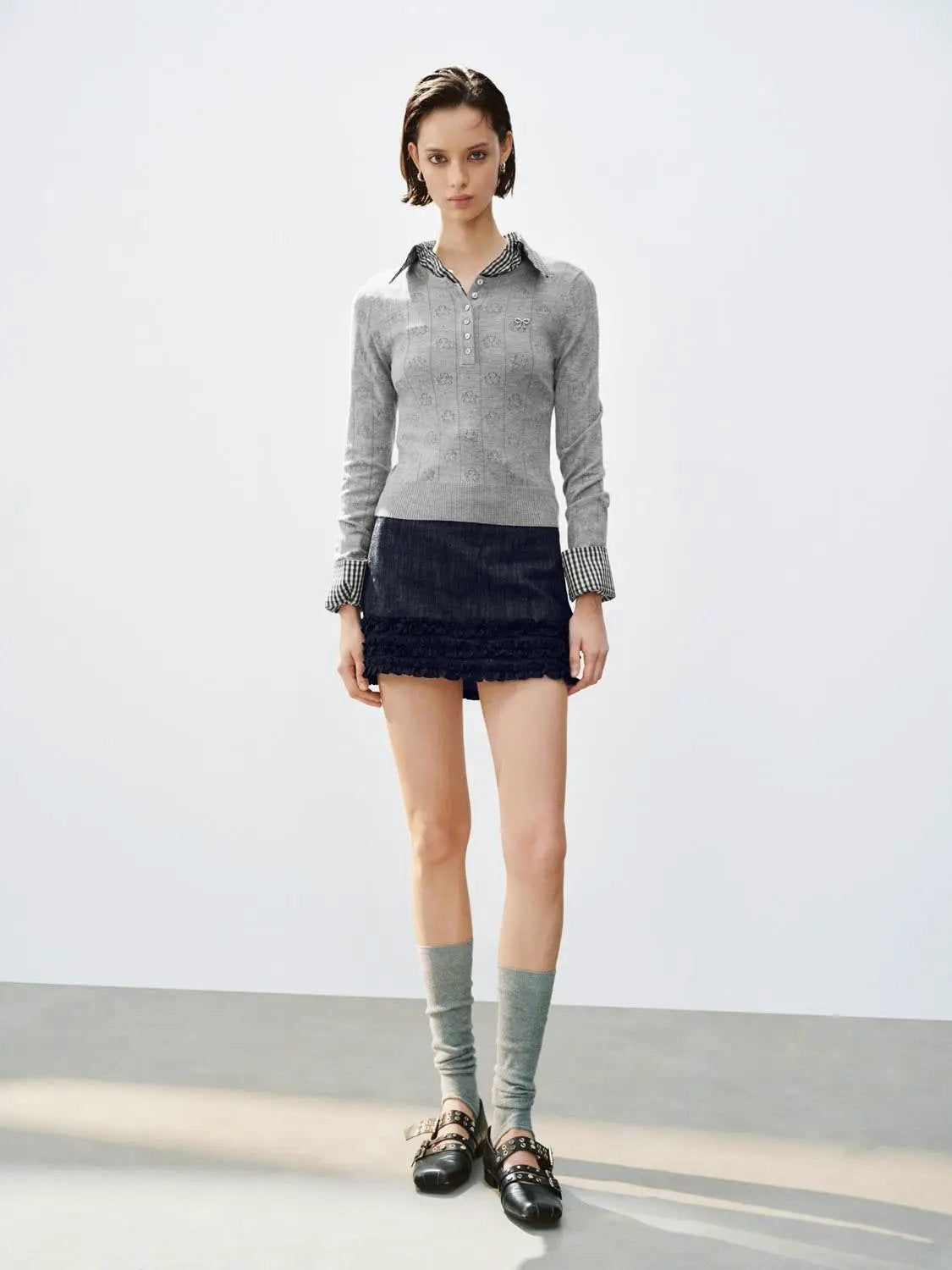Textured button-front long-sleeve crew-neck sweater, gray knit, worn with a dark mini skirt and gray leg warmers.