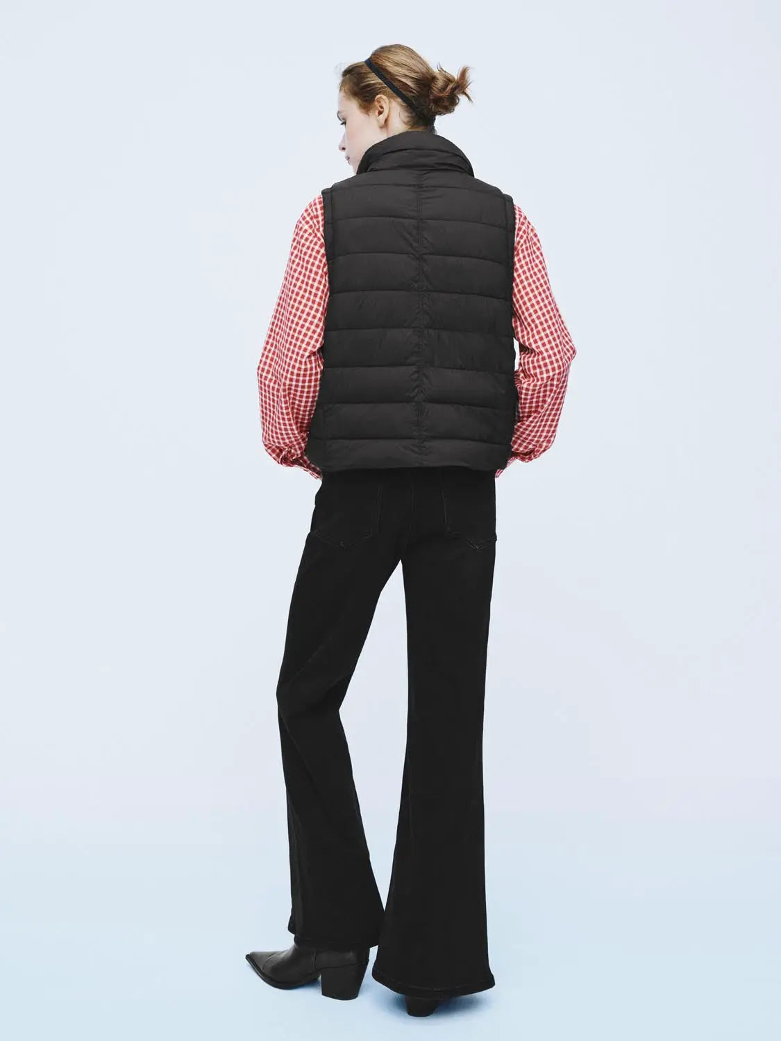 Padded jacket, black quilted vest-style outerwear worn over a red checkered shirt