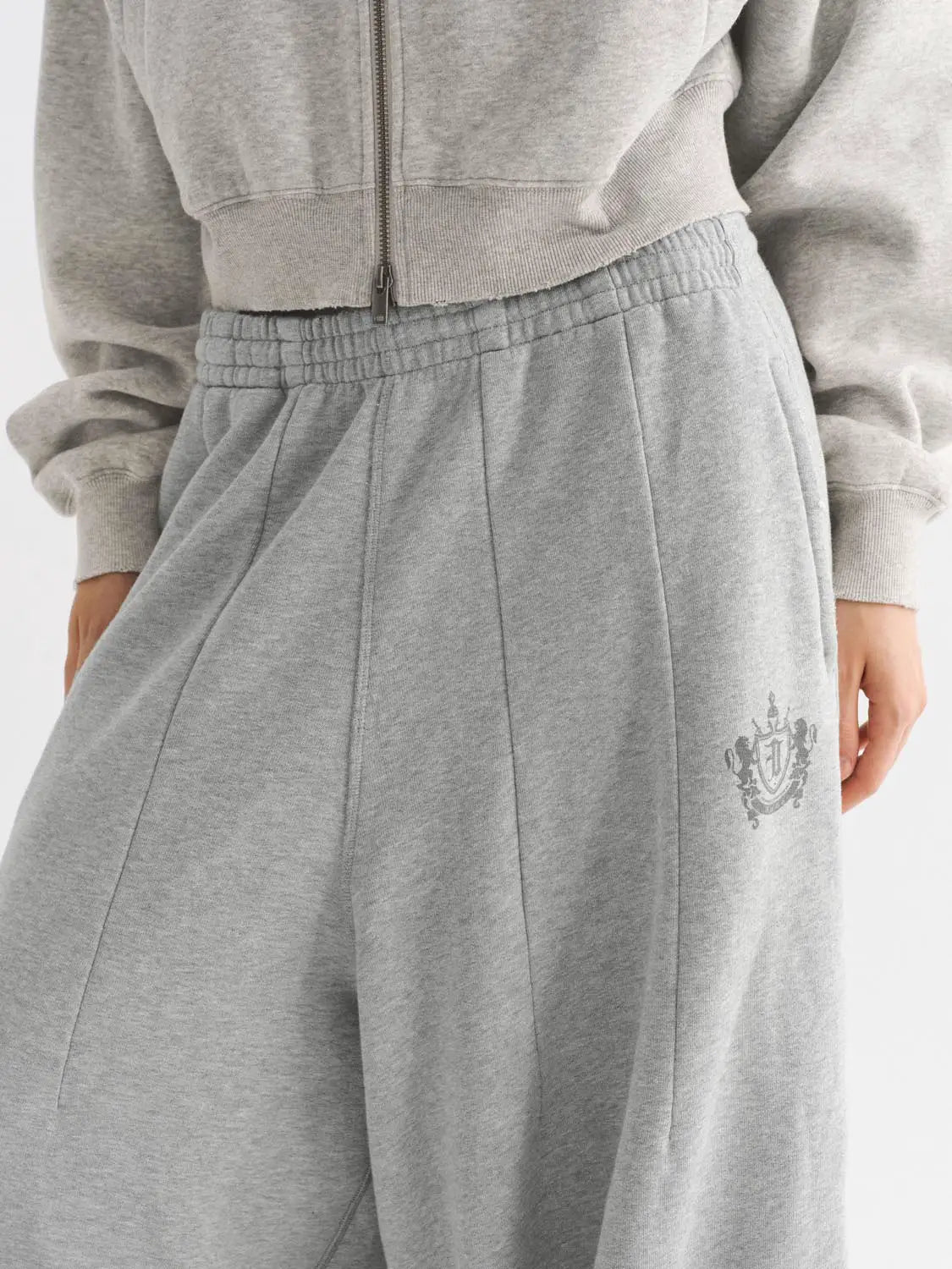 Harem pants in heather gray with elastic waistband and small crest logo at hip.