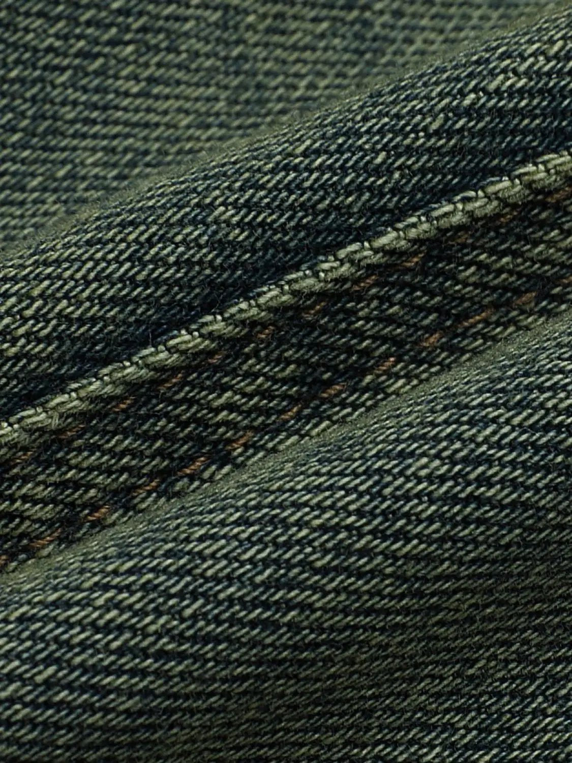 Cropped denim shirt fabric close-up in blue indigo with visible stitching