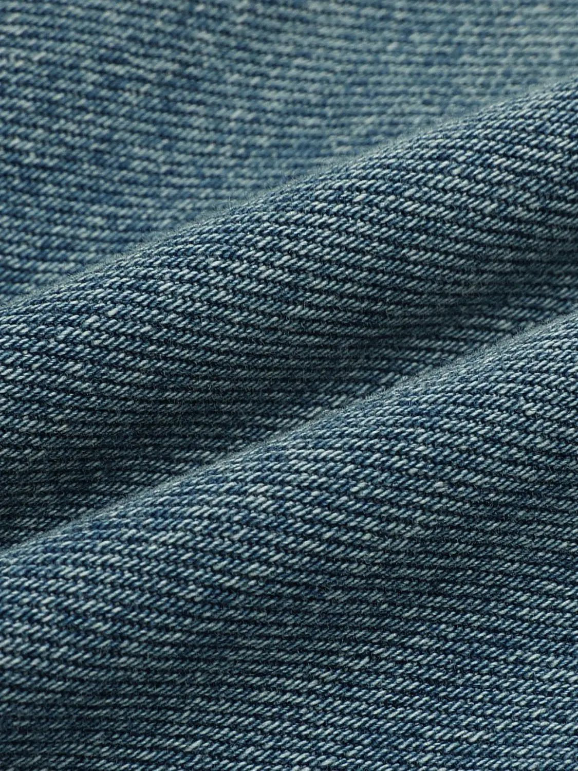 Jeans fabric close-up in blue denim showing textured weave