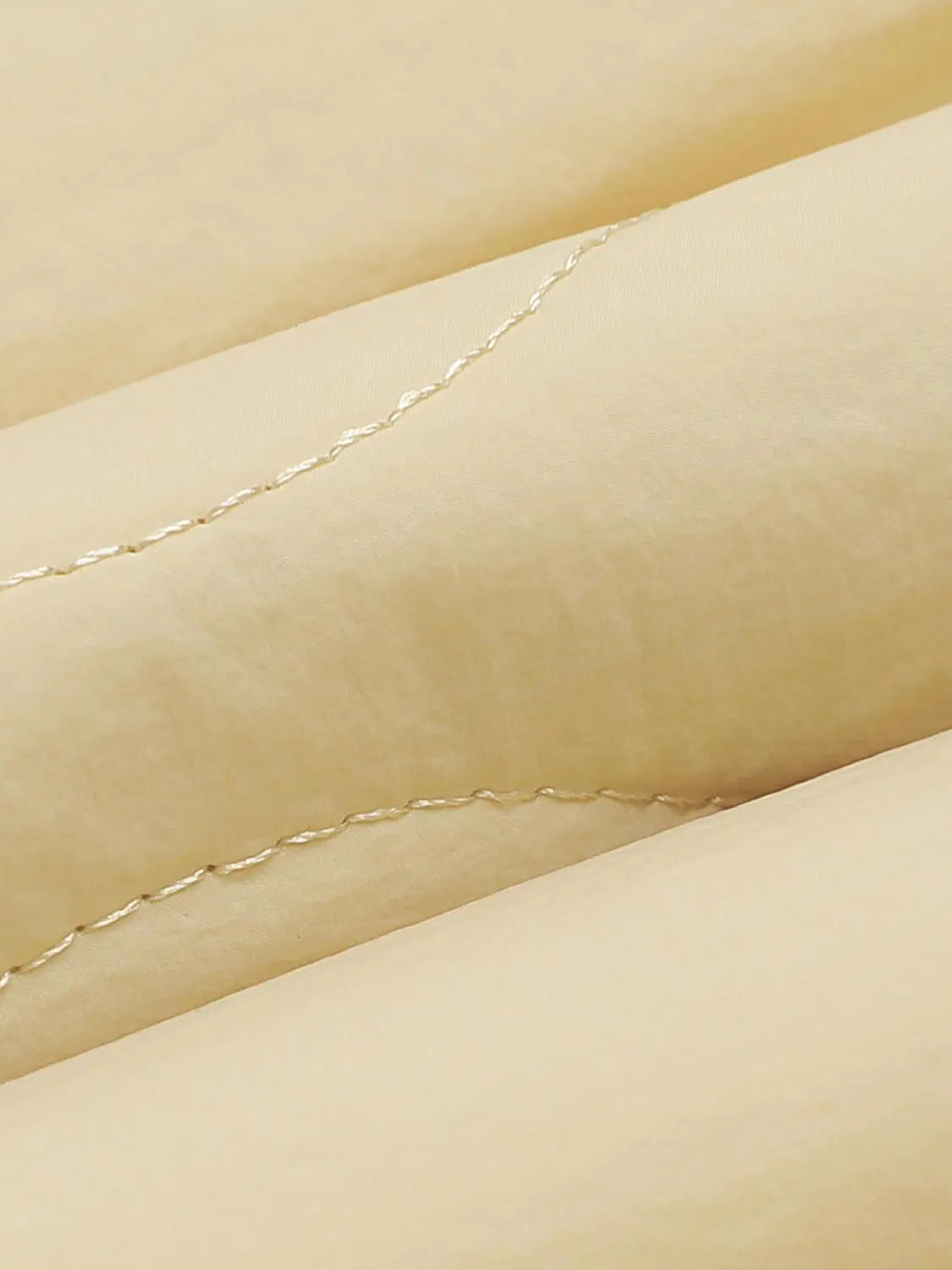 Padded Jacket beige fabric close-up with a visible white topstitch seam, Urban Revivo Fashion