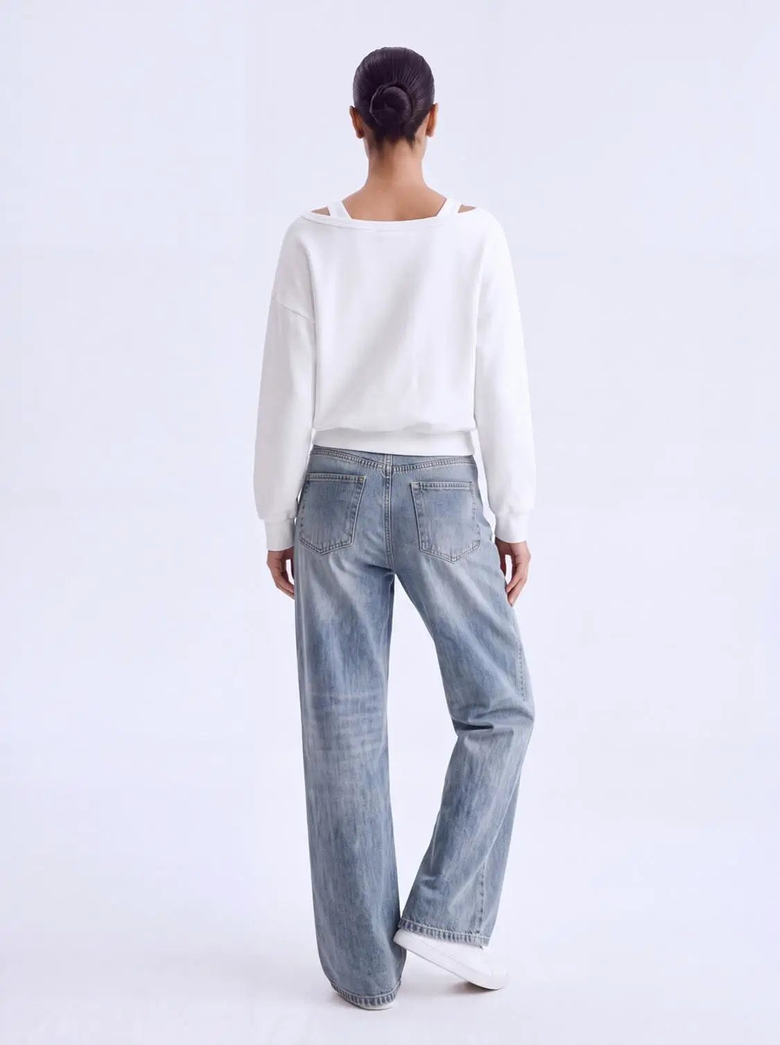 2-in-1 off-shoulder long-sleeve sweatshirt, white with ribbed hem; two-piece outfit with light-wash jeans.