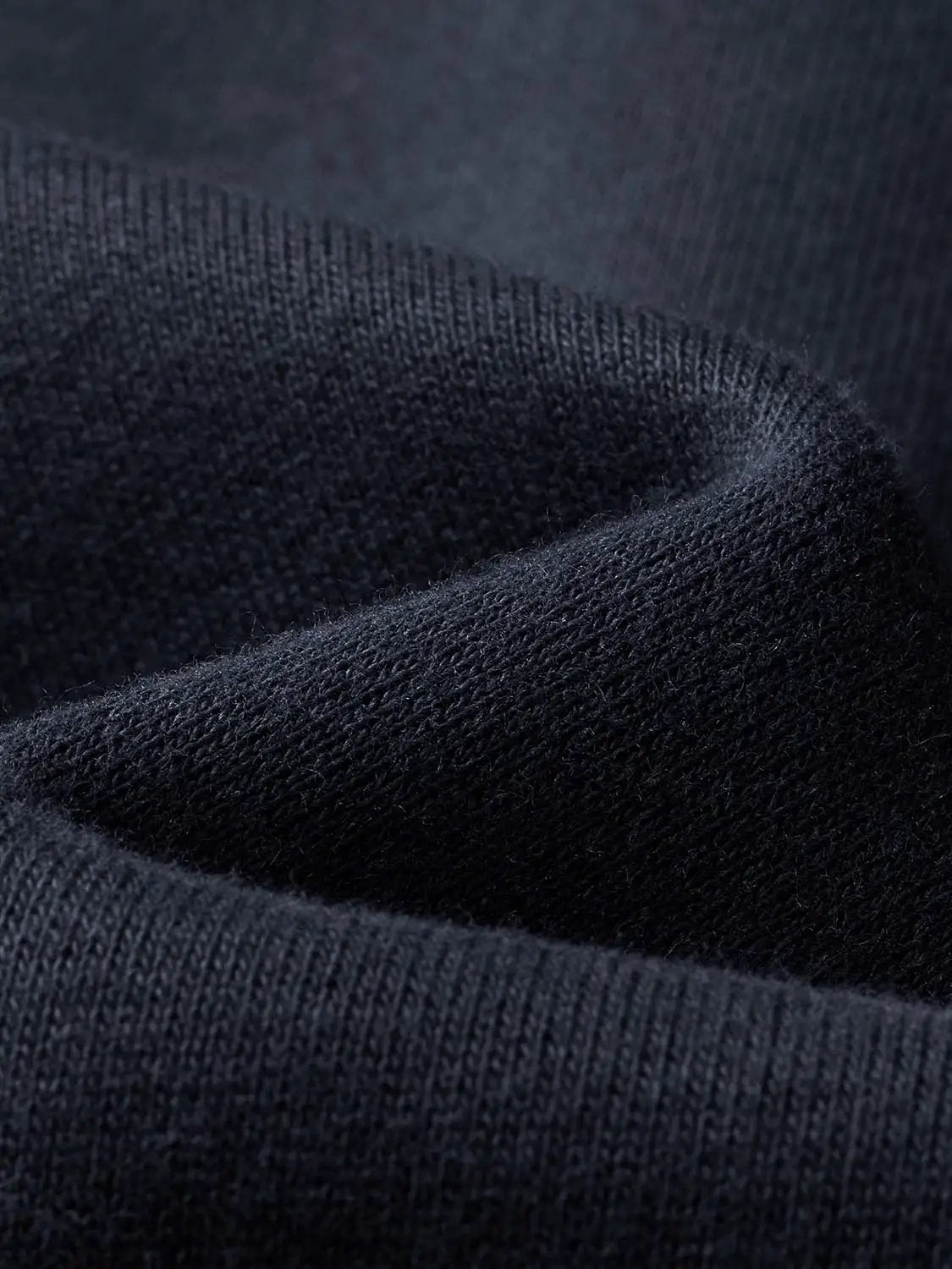 Sweatshirt fabric close-up in dark navy knit with ribbed edge.