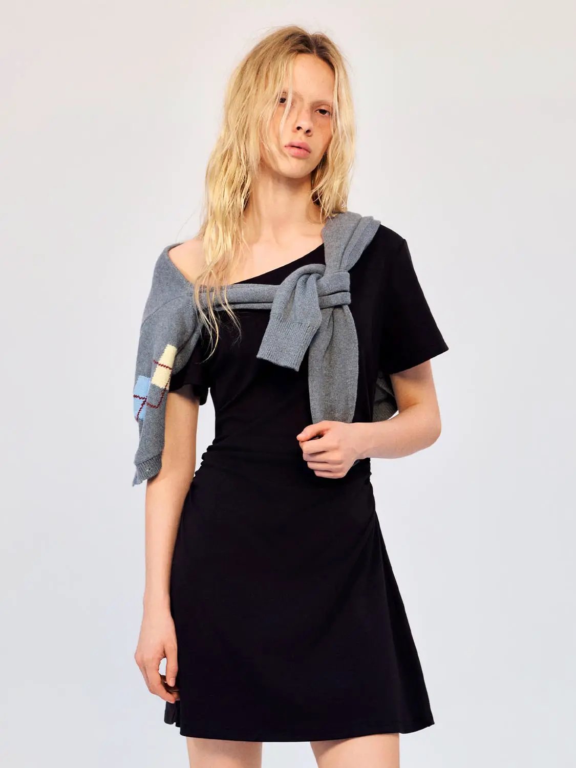 Cotton A-line dress, black, knee-length on model with gray knit sweater draped over shoulders