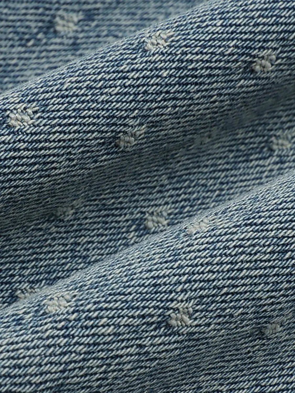 Wide-leg blue denim jeans with small distressed patches and visible stitching