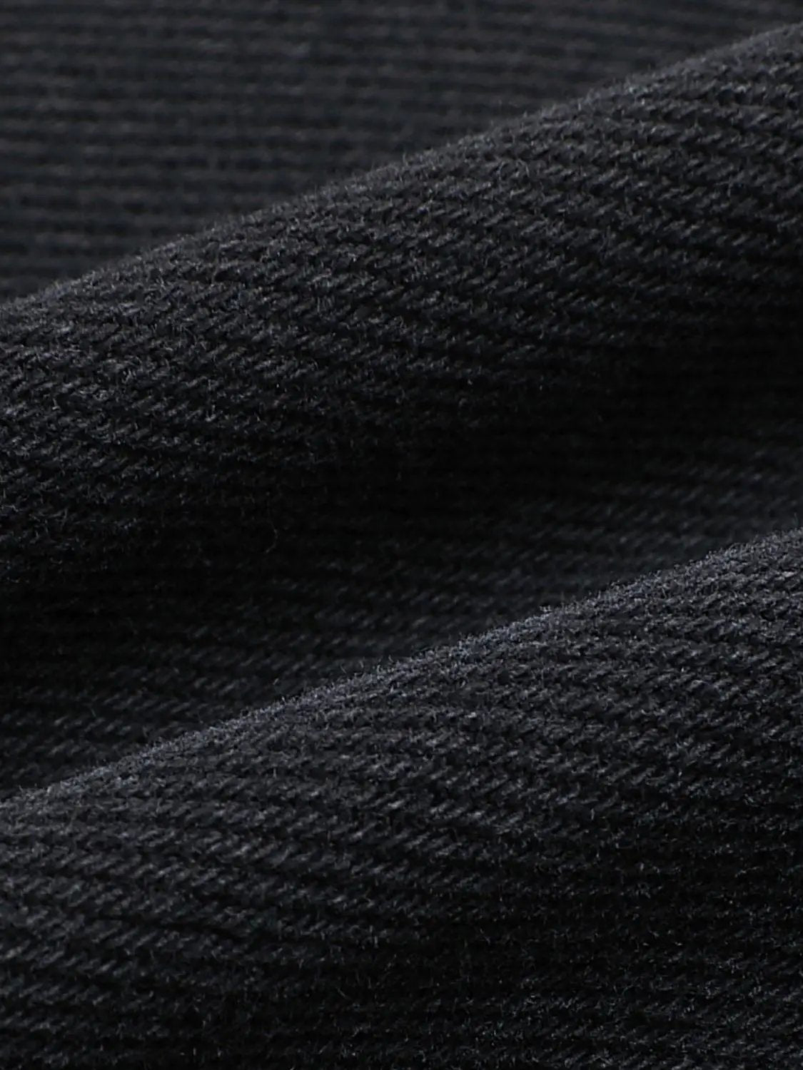 Jeans close-up of black denim fabric texture with weave