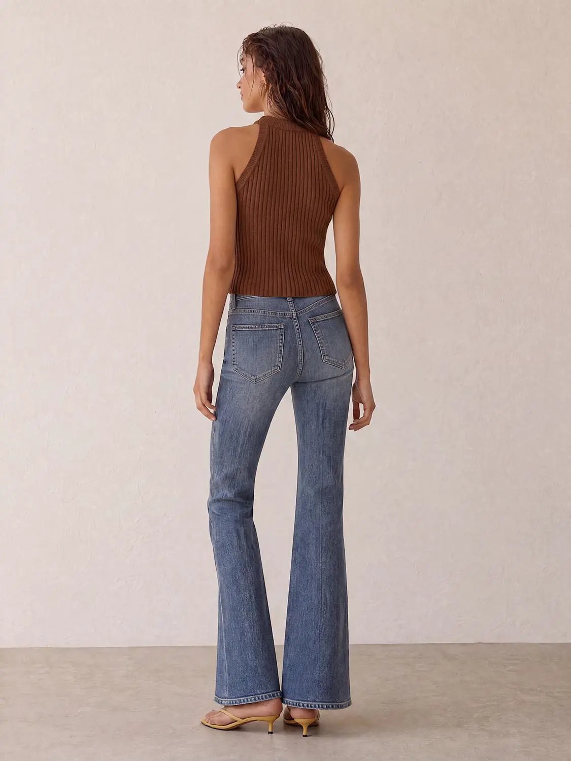 Knitted vest top, brown ribbed knit, back view of model in blue jeans.