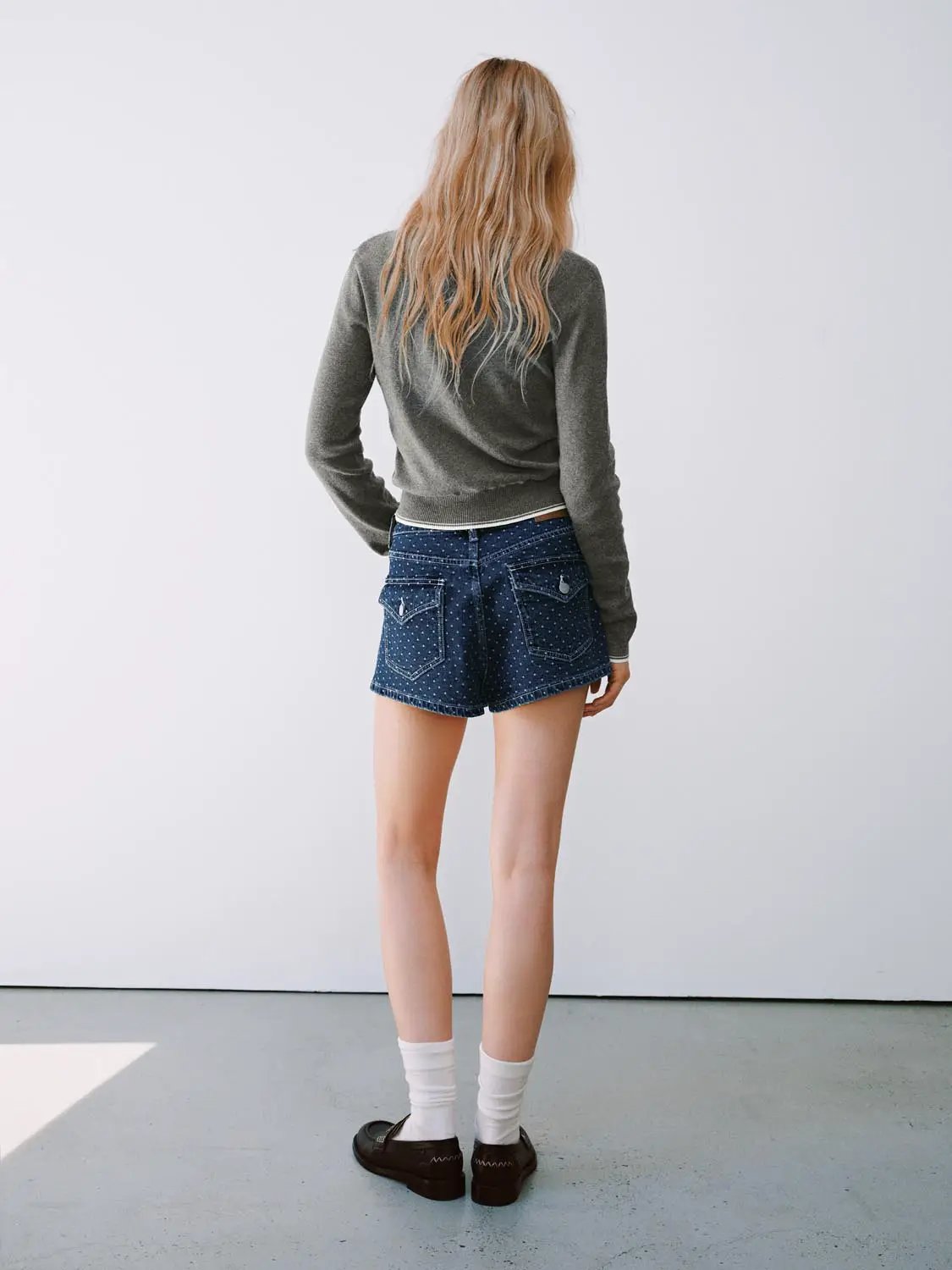 Knit T-Shirt in heather gray worn with blue polka-dot denim shorts, back view