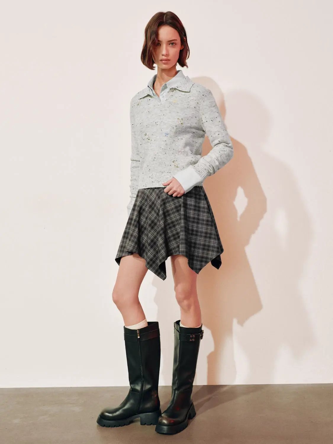 Embroidered floral knit polo-collar sweater; light-gray speckled knit with long sleeves, paired with a plaid skirt