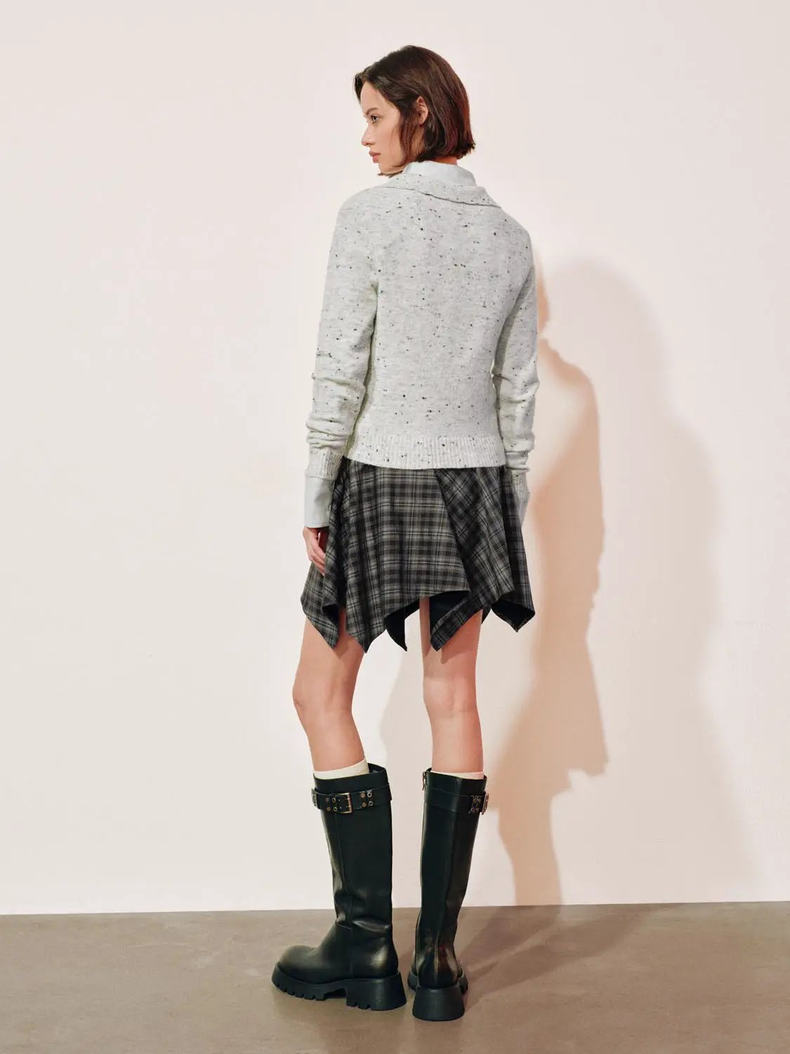 Embroidered floral knit polo-collar sweater in light grey speckled knit, paired with a plaid wrap skirt and knee-high boots.