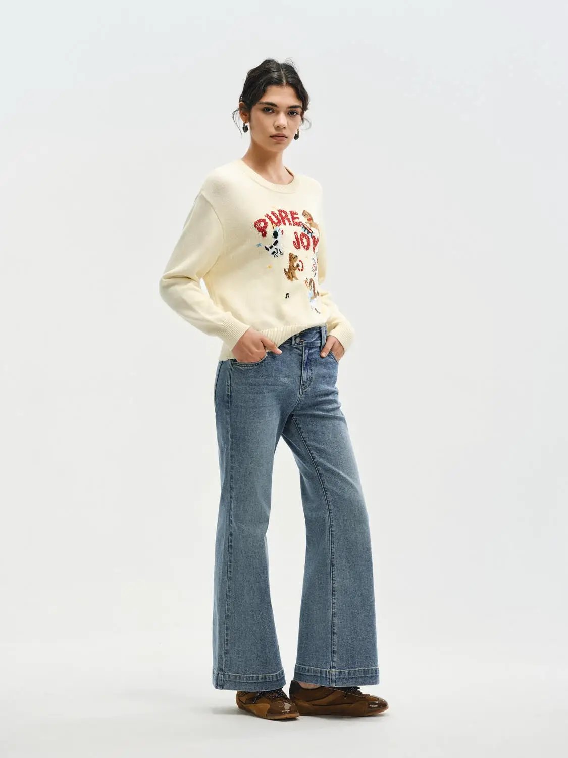 Knitted sweater by Urban Revivo Fashion in cream with graphic print; paired with blue denim jeans.