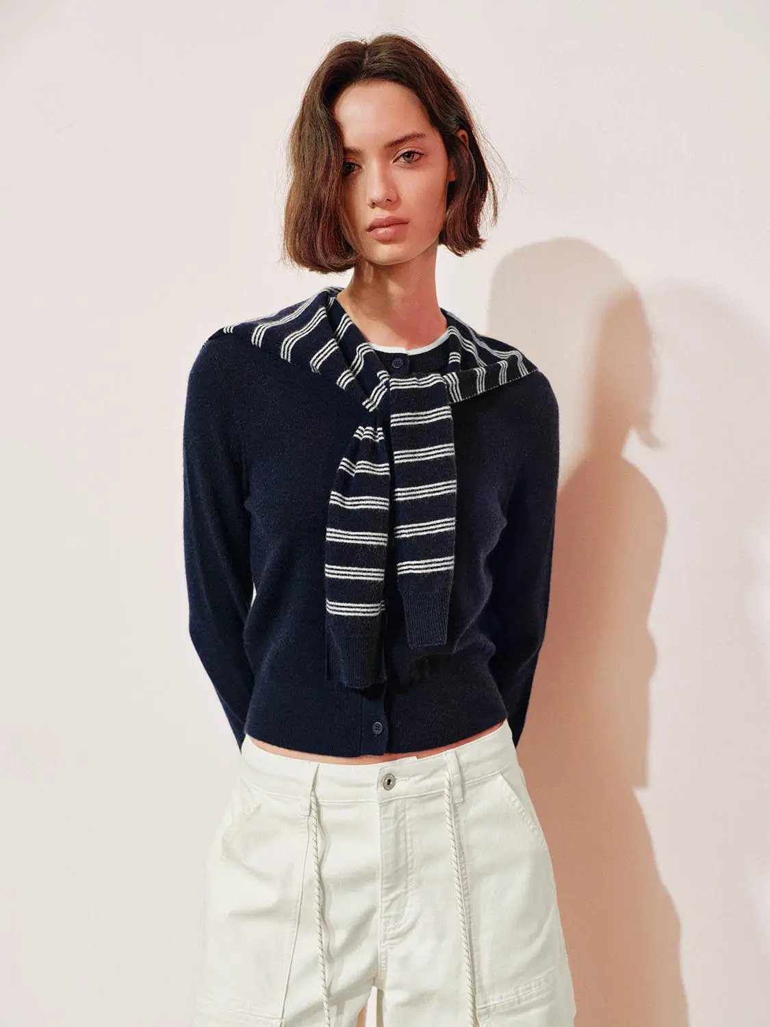 Knit striped shawl cardigan navy with button front, long sleeves; striped scarf draped at neck.