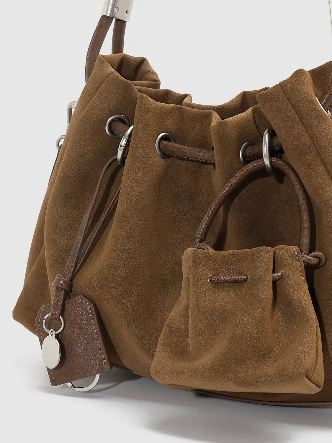 Shoulder & crossbody bag in tan suede with drawstring top, silver hardware, and a small attached pouch