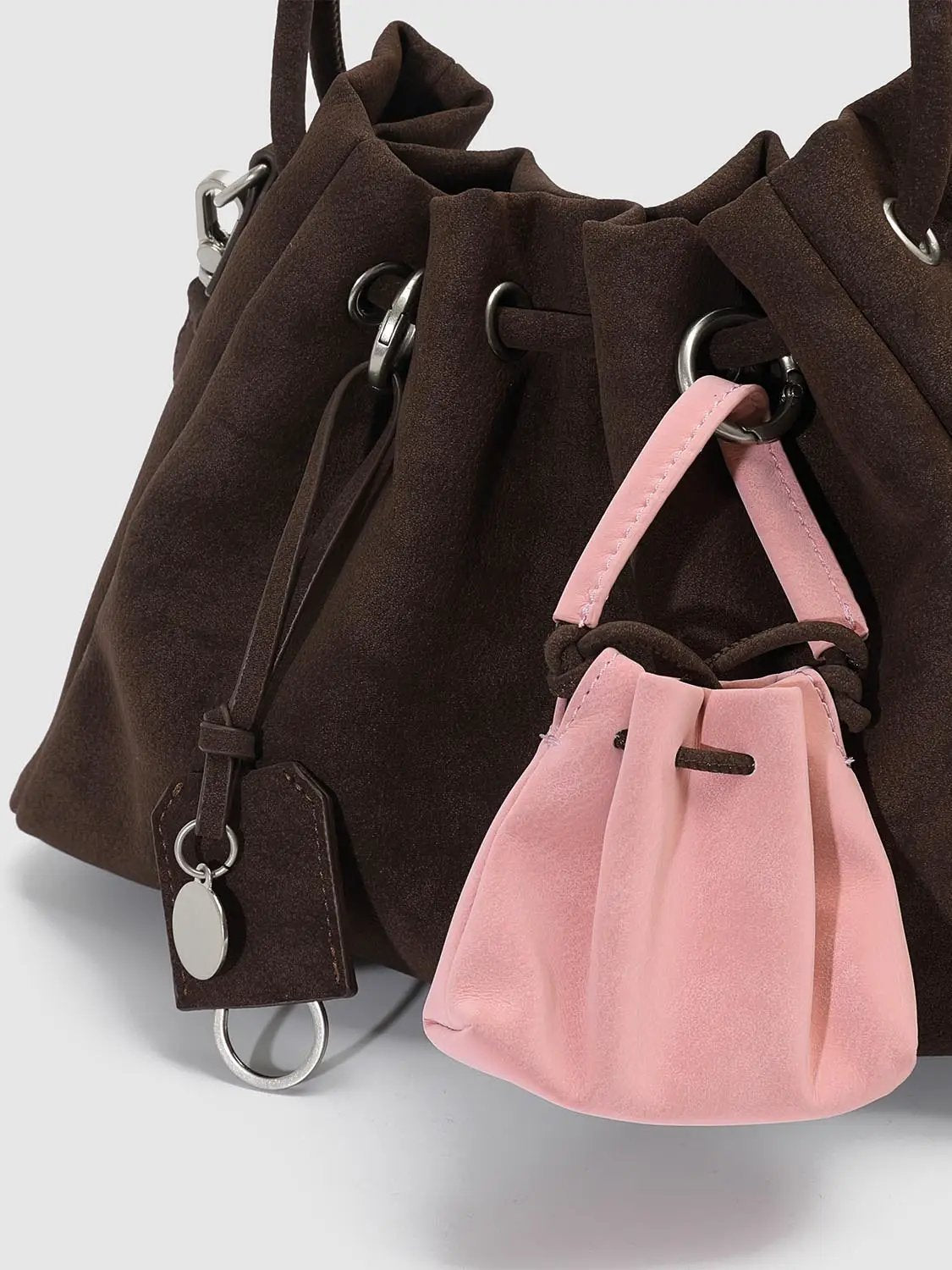 Shoulder & crossbody bag by Urban Revivo Fashion, dark brown suede with pink mini pouch accessory.