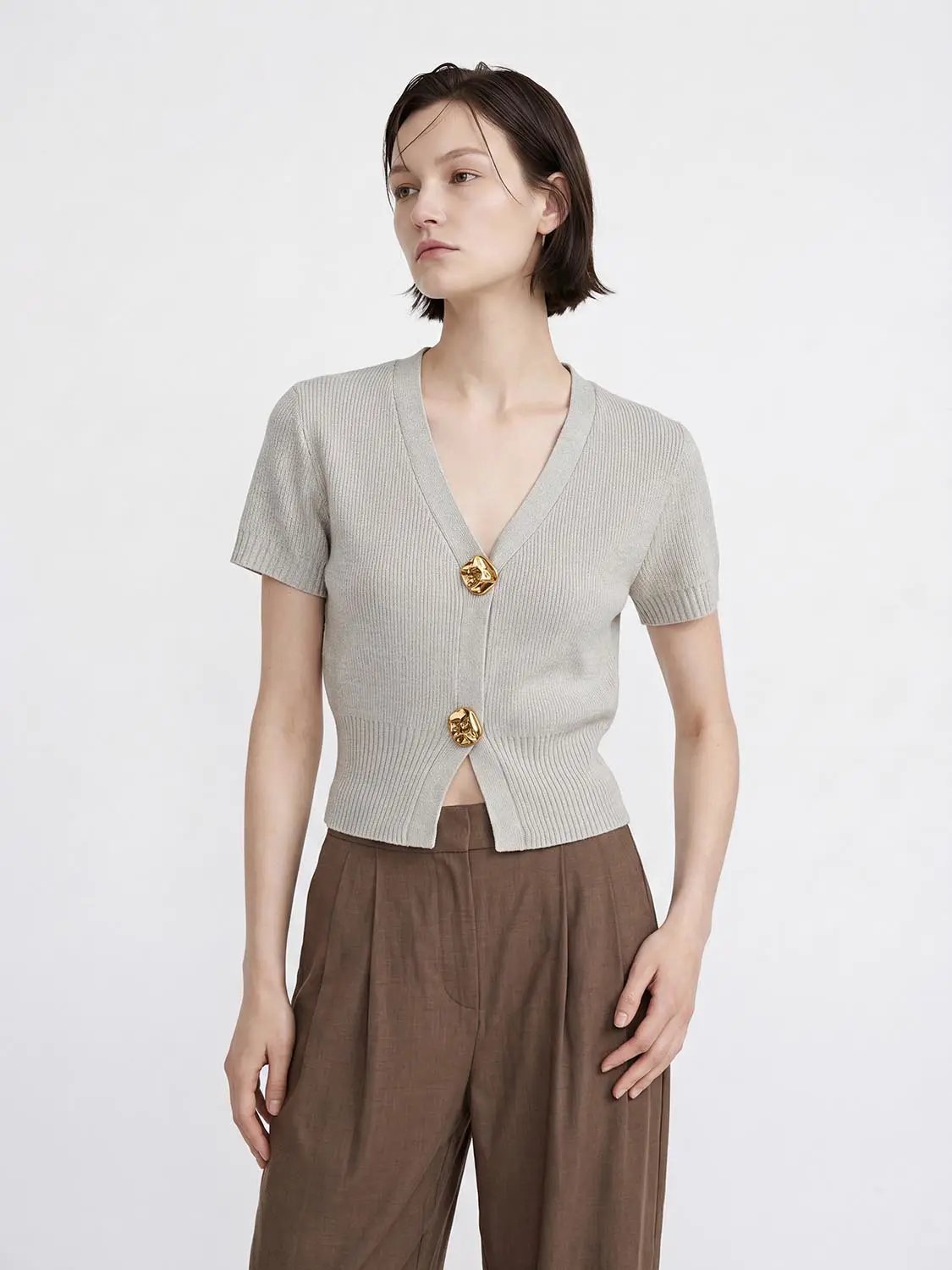Short sleeve knitted cardigan in light gray ribbed knit with V-neck, cropped hem and gold-tone buttons.