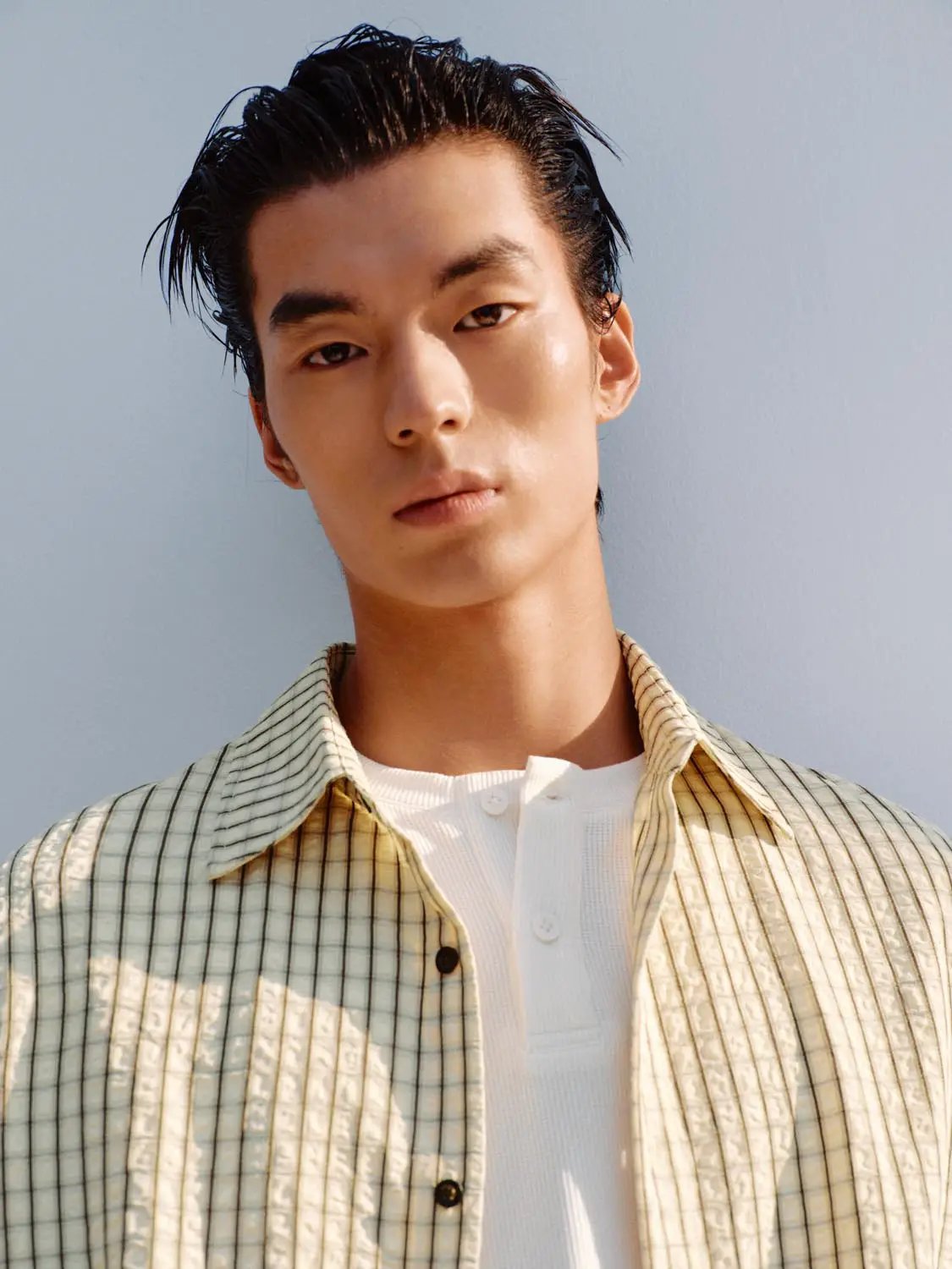 Button-front shirt in light beige with navy stripes worn over a white tee