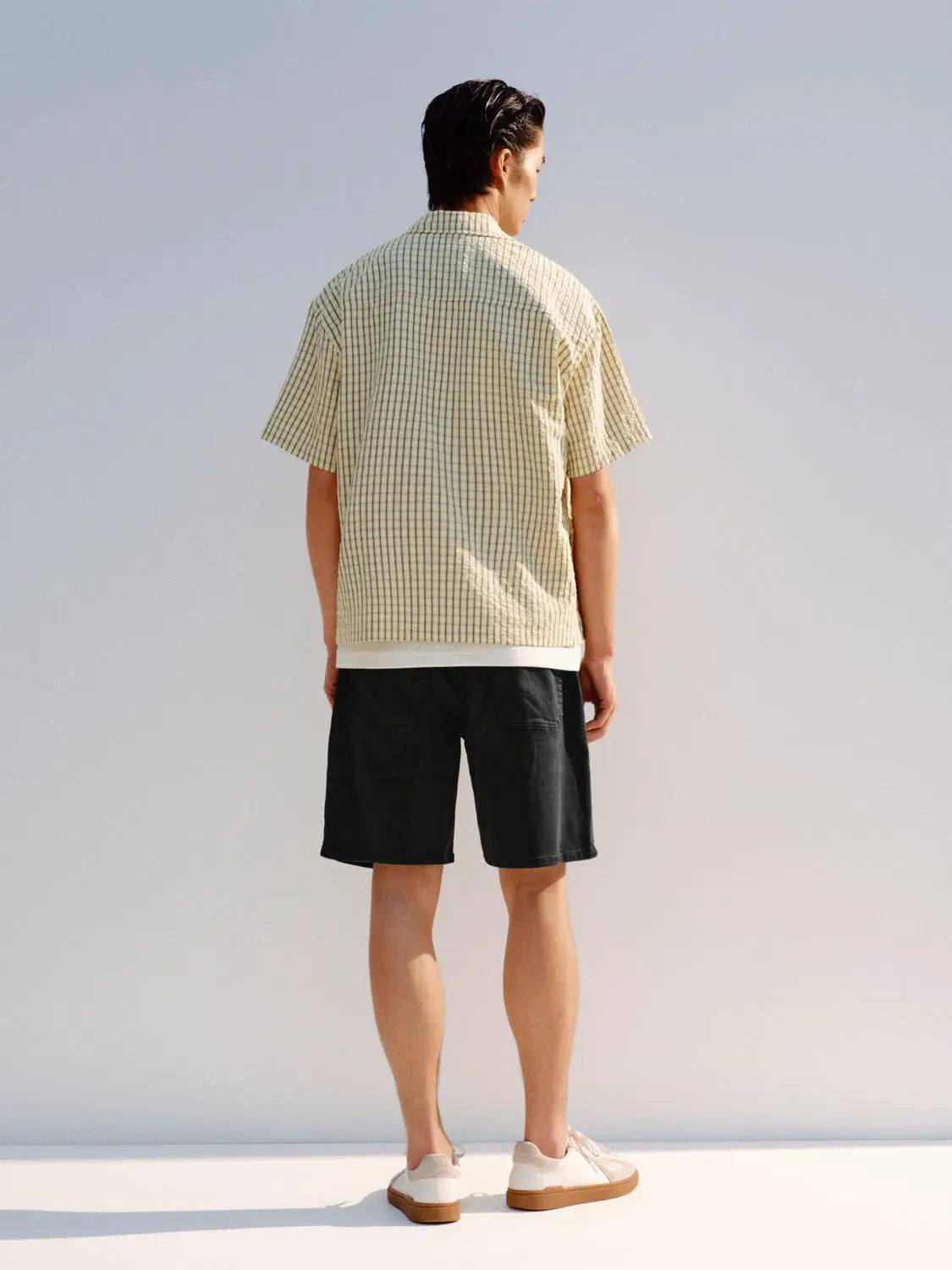 Button-front Shirt, beige checkered short-sleeve on model, paired with black shorts