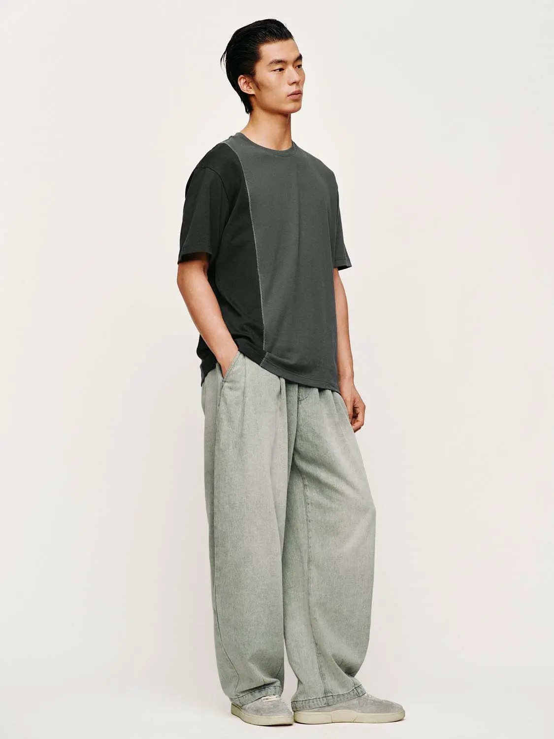 Denim jeans in light gray with a wide-leg cut, worn by a male model