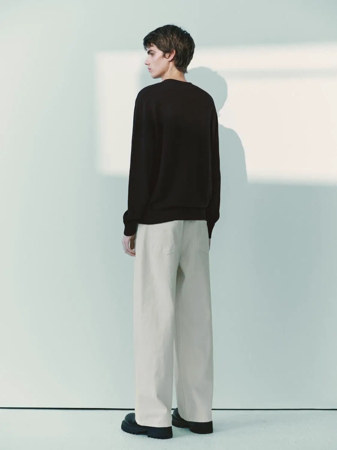 Knit T-Shirt, black long-sleeve knit top worn by a male model with beige wide-leg pants
