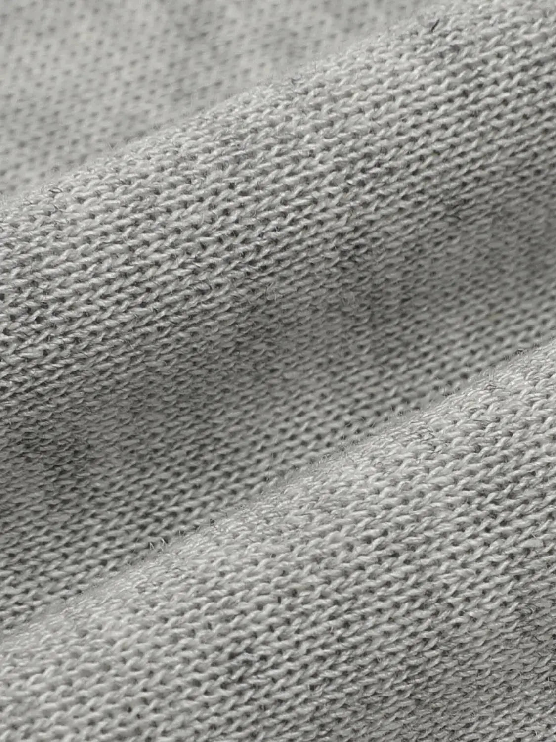 Knitted T-Shirts fabric close-up in light gray knit texture.