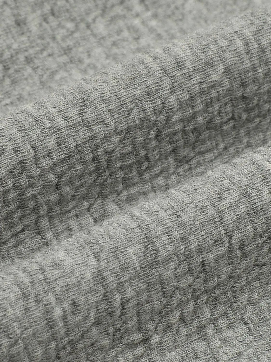 Sweatshirts fabric close-up in heather grey; soft knit texture with subtle ribbing