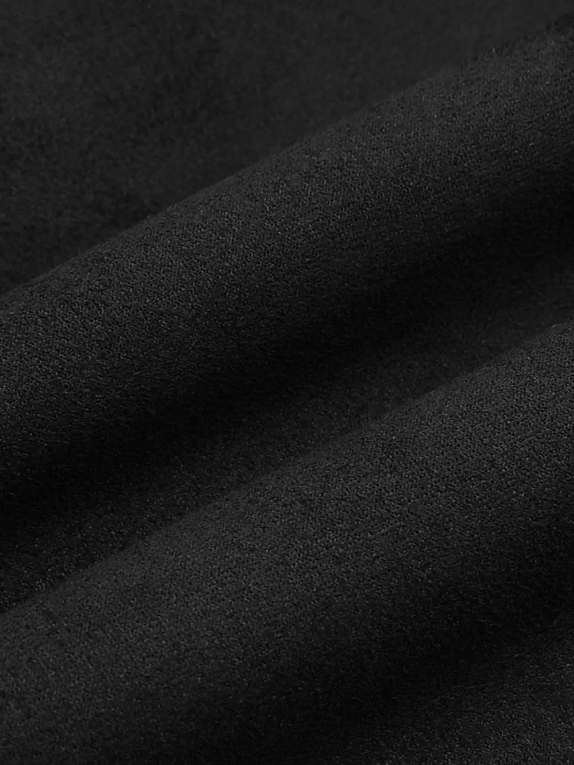 Jacket close-up in black textured fabric, showcasing its texture.