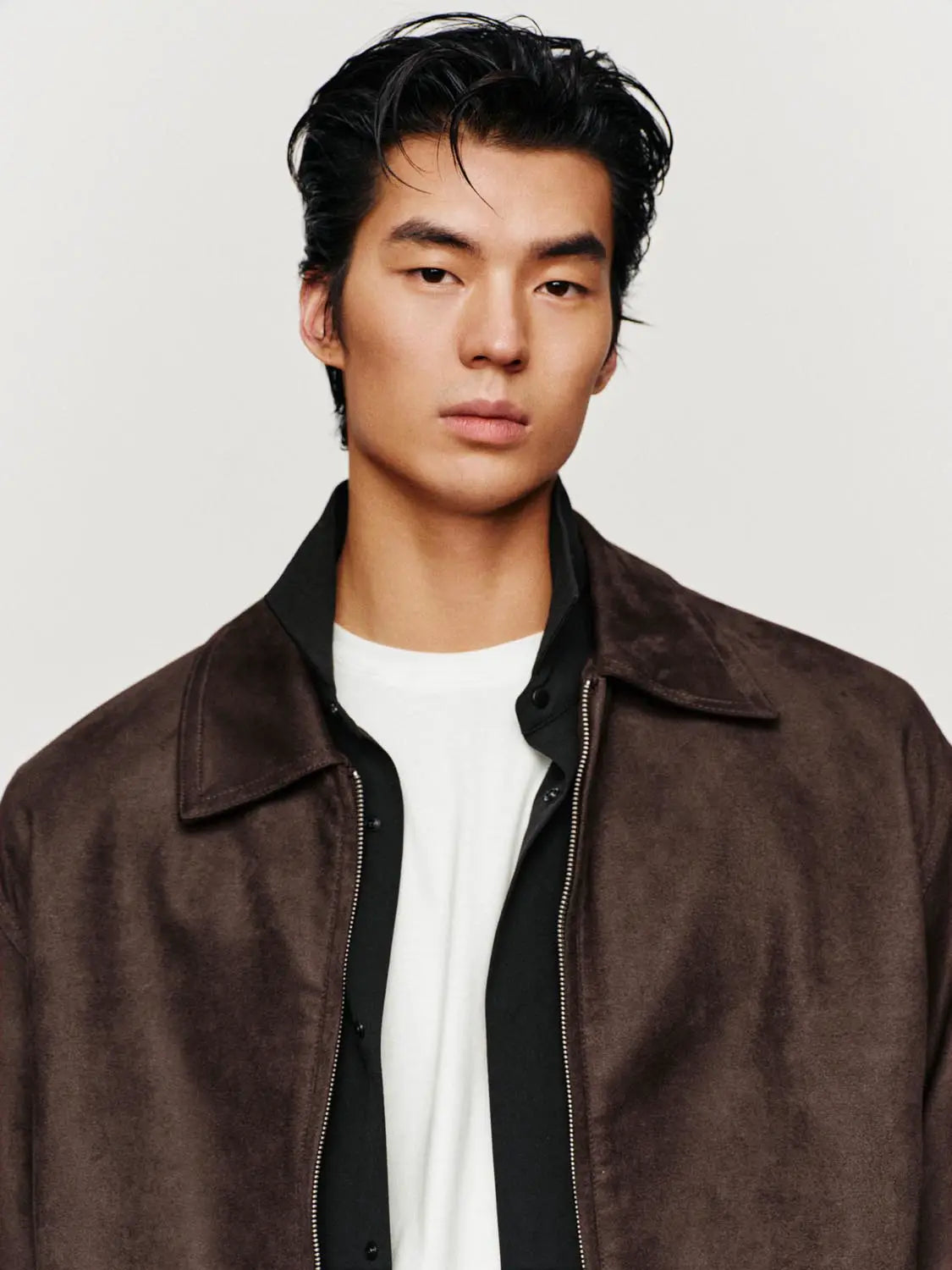 Brown suede jacket over black shirt and white tee on male model