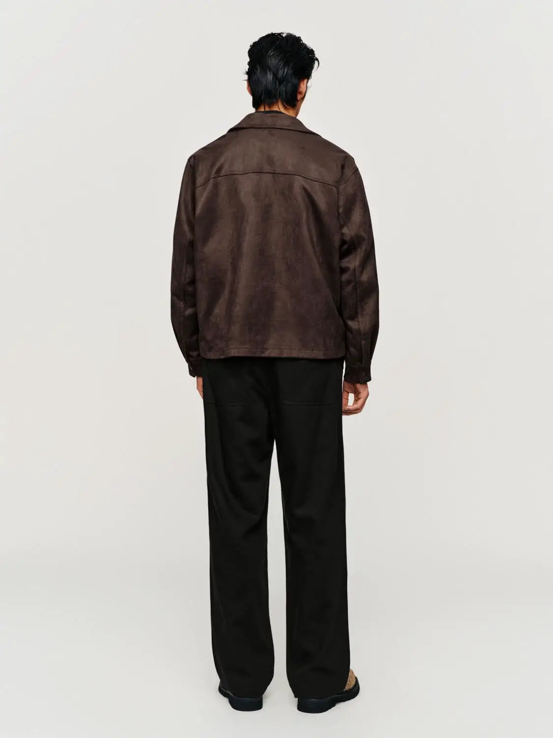 Jacket, brown suede-like material, waist-length, back view on model wearing black pants