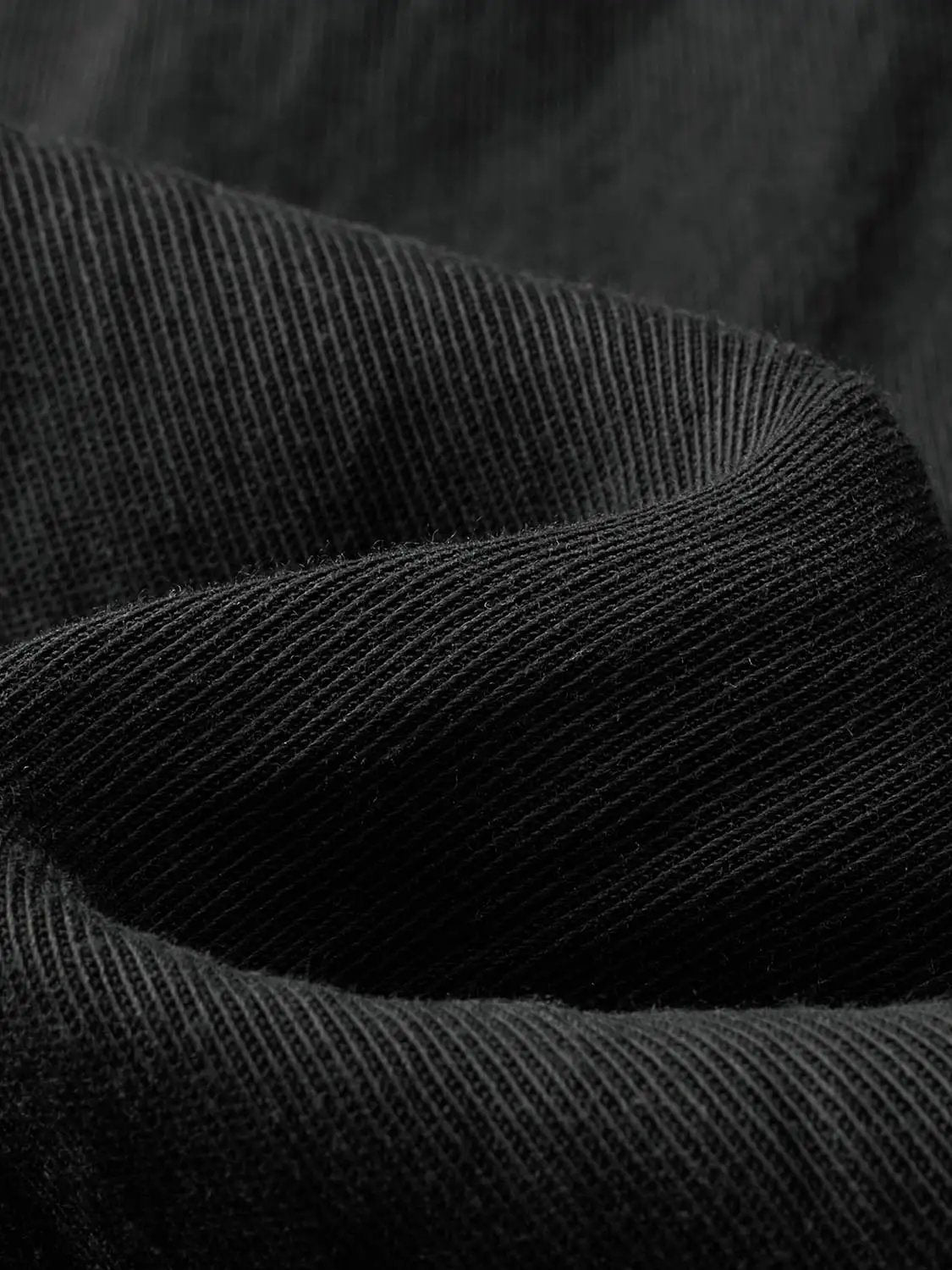 Cardigan shirt in black knit fabric with ribbed texture.