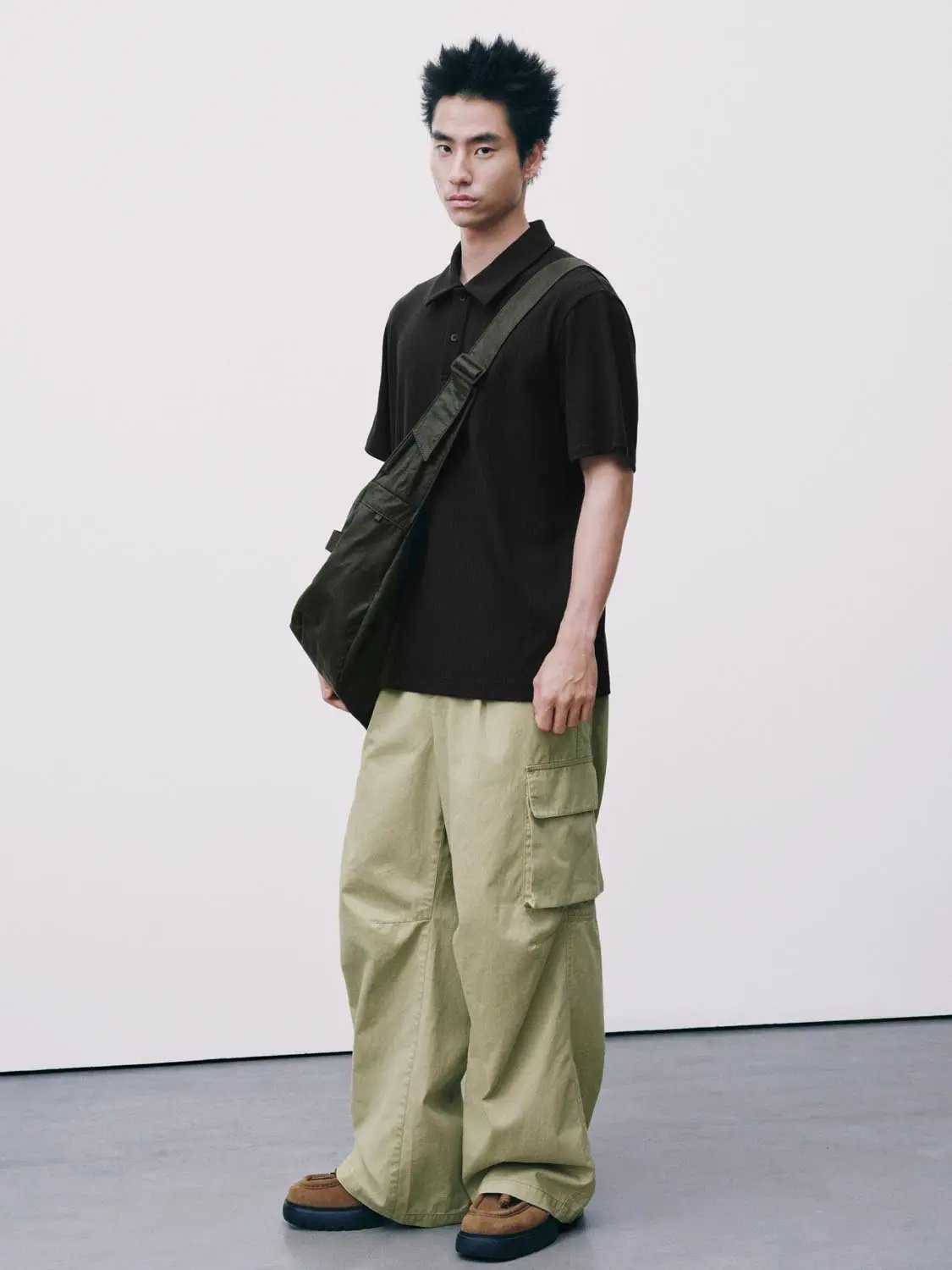 Polo shirt, black, paired with olive crossbody bag and beige cargo pants