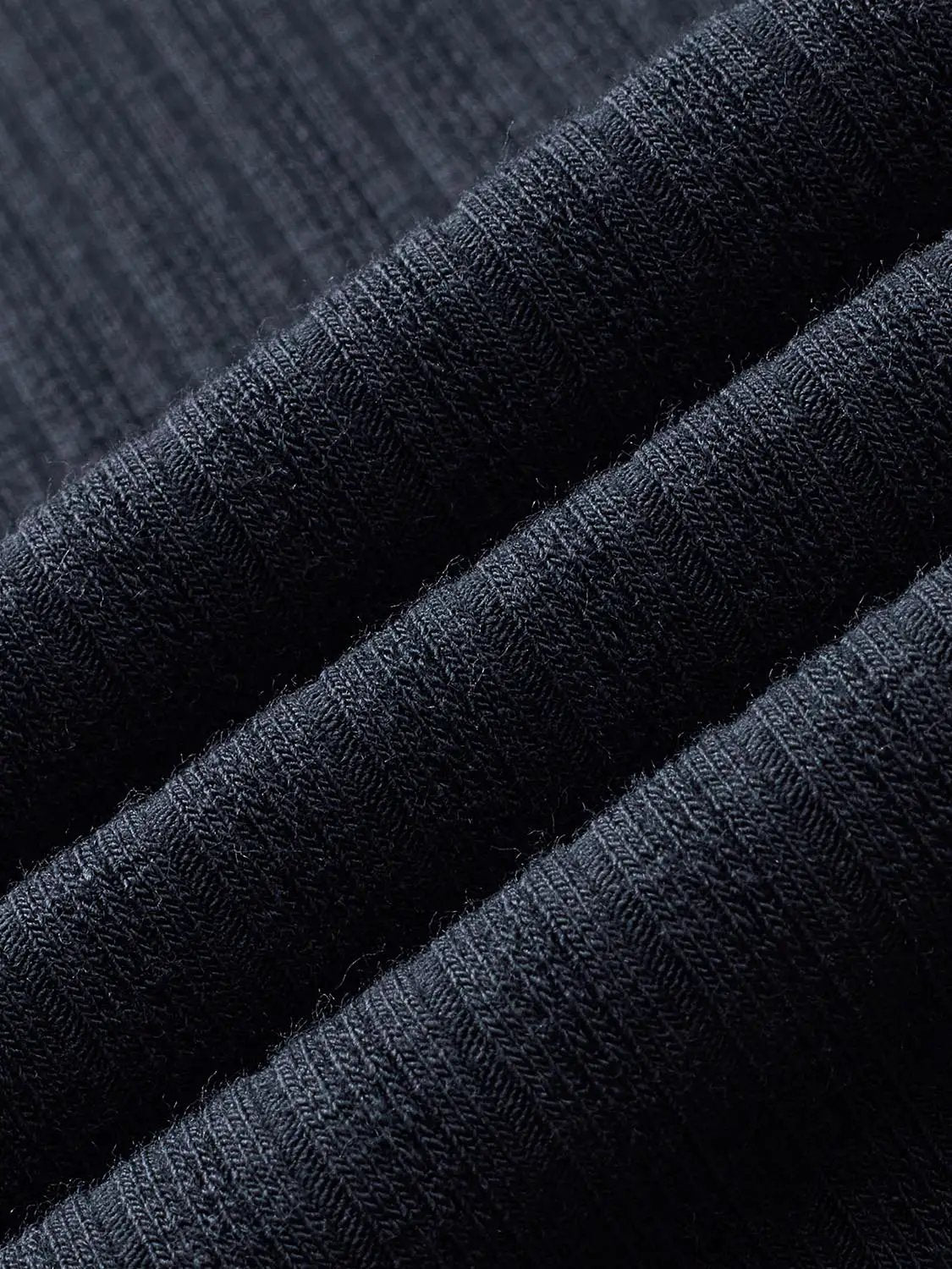 Polo shirt fabric close-up in dark navy with textured knit.