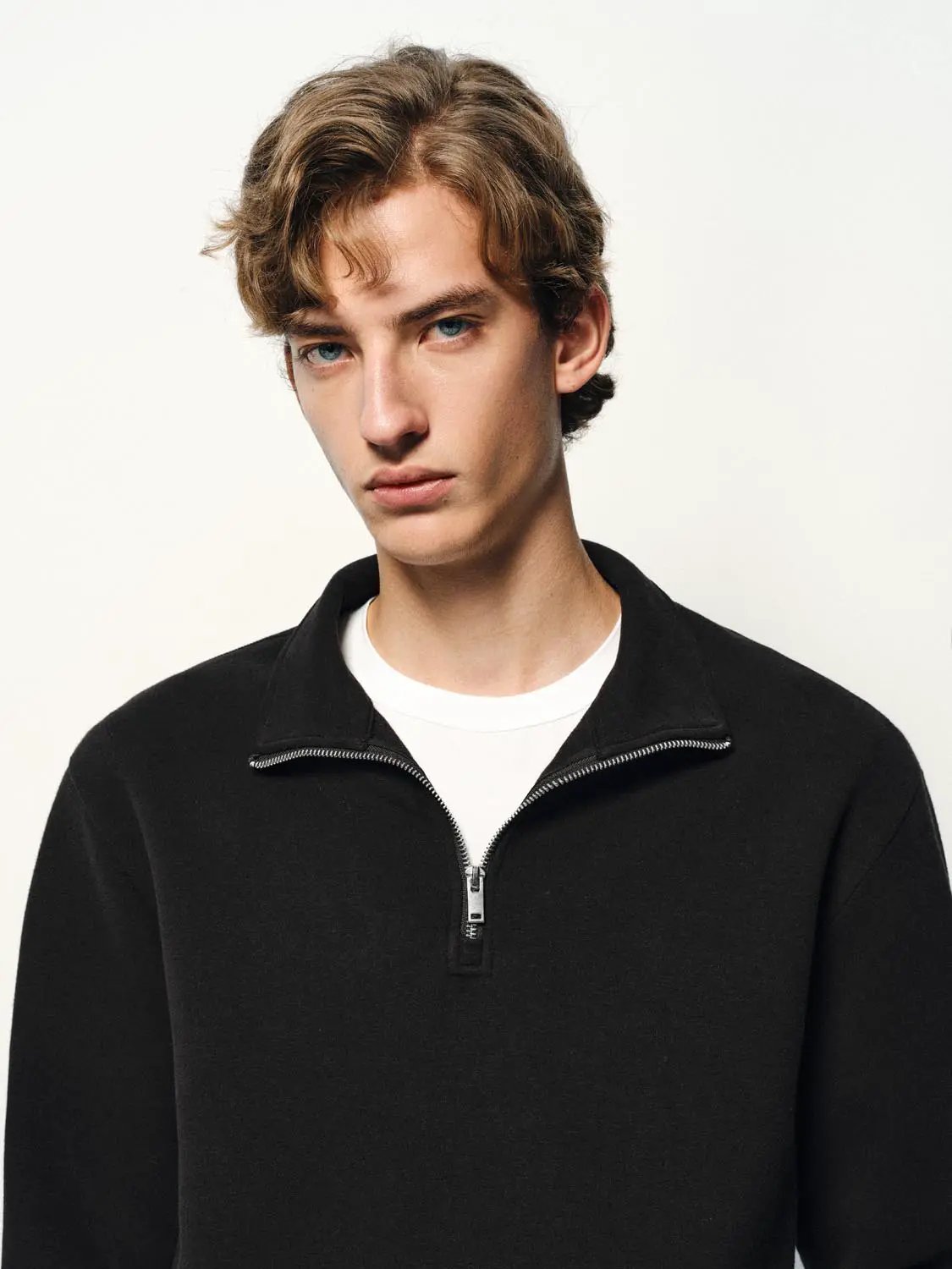 Sweatshirt, black quarter-zip pullover with silver zipper on a model
